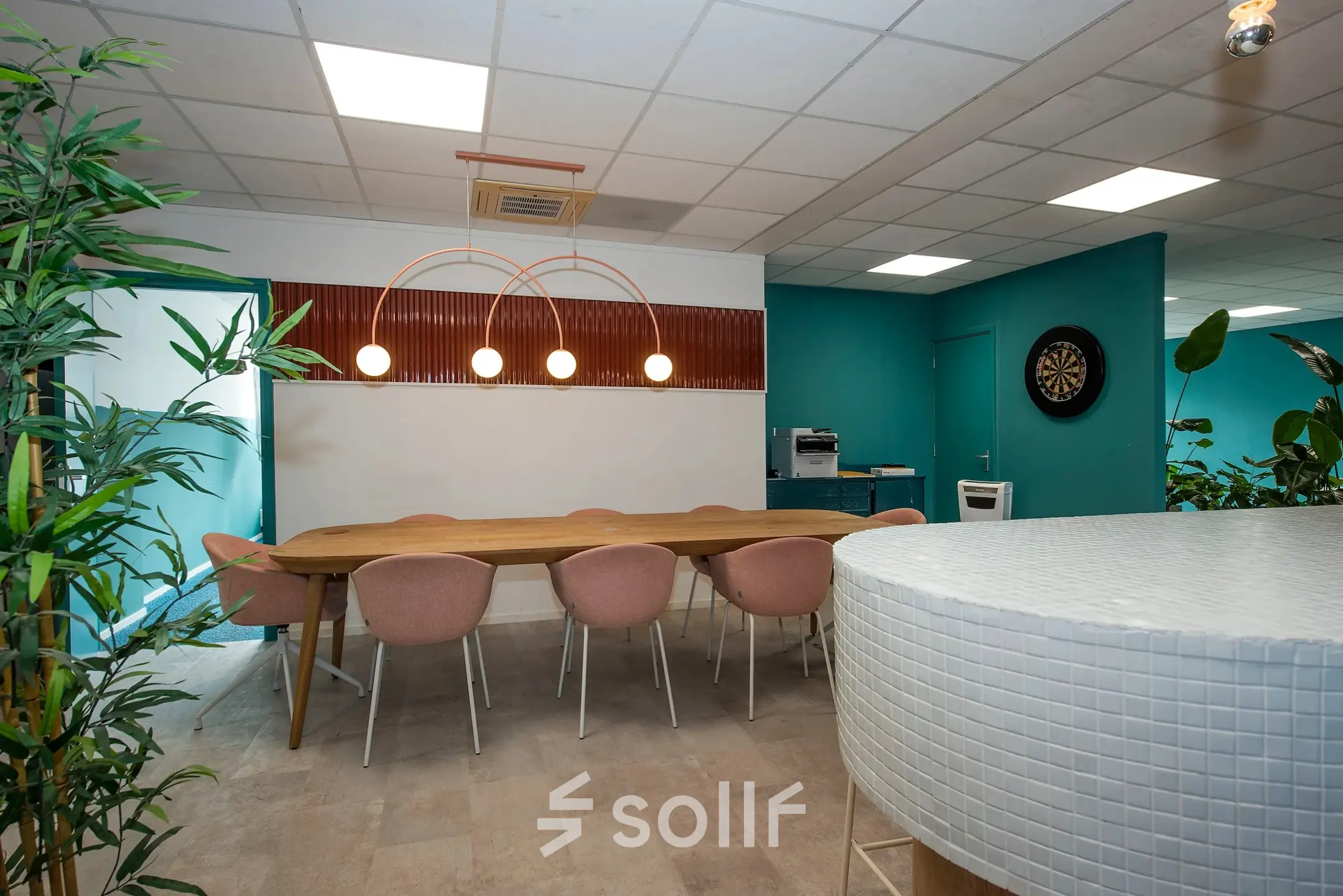 Furnished office at Boddenkampsingel 95 in Enschede with a long wooden table, pink chairs, and a dartboard, available for office space rental.