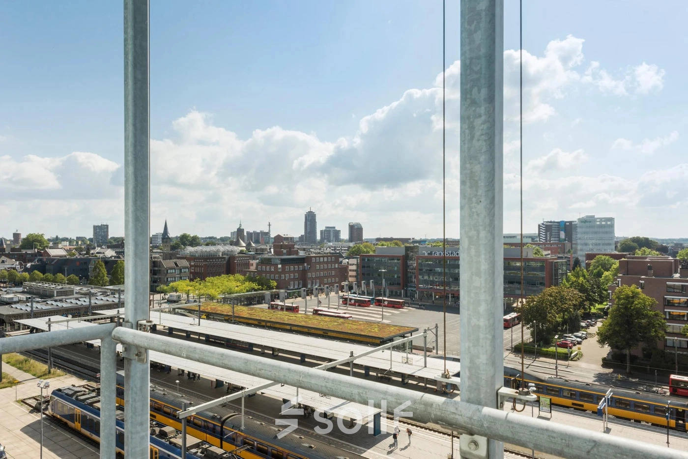 Exterior view overlooking Enschede cityscape from Brandweerstraat 20-30, offering a glimpse of nearby train tracks and urban surroundings.