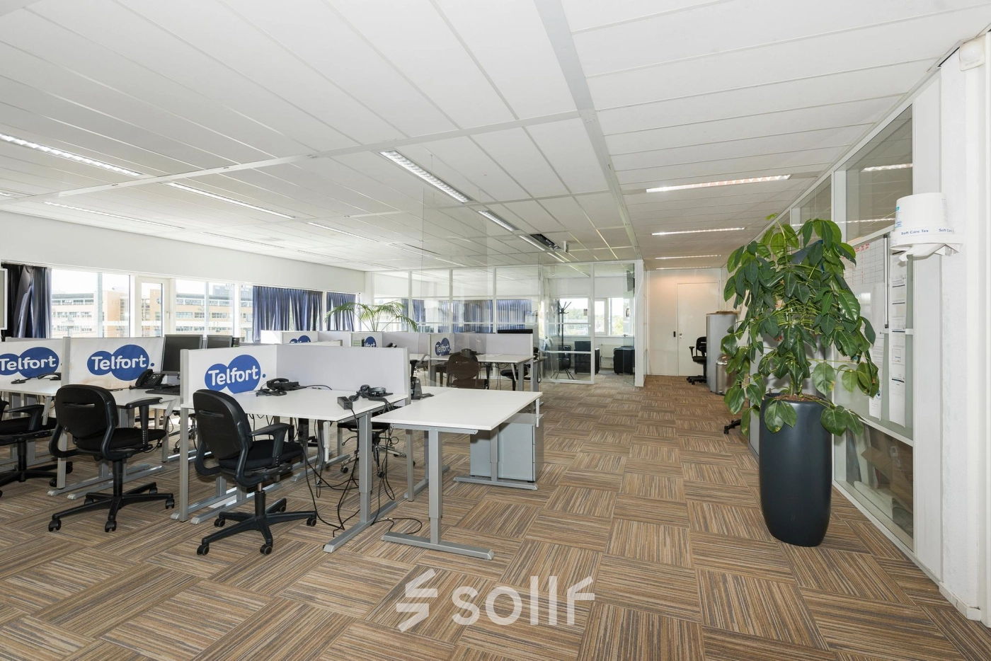 Bright open-plan office space with modular workstations and glass partitions at Brandweerstraat 20-30, Enschede. Ideal for businesses seeking flexible office space rental.