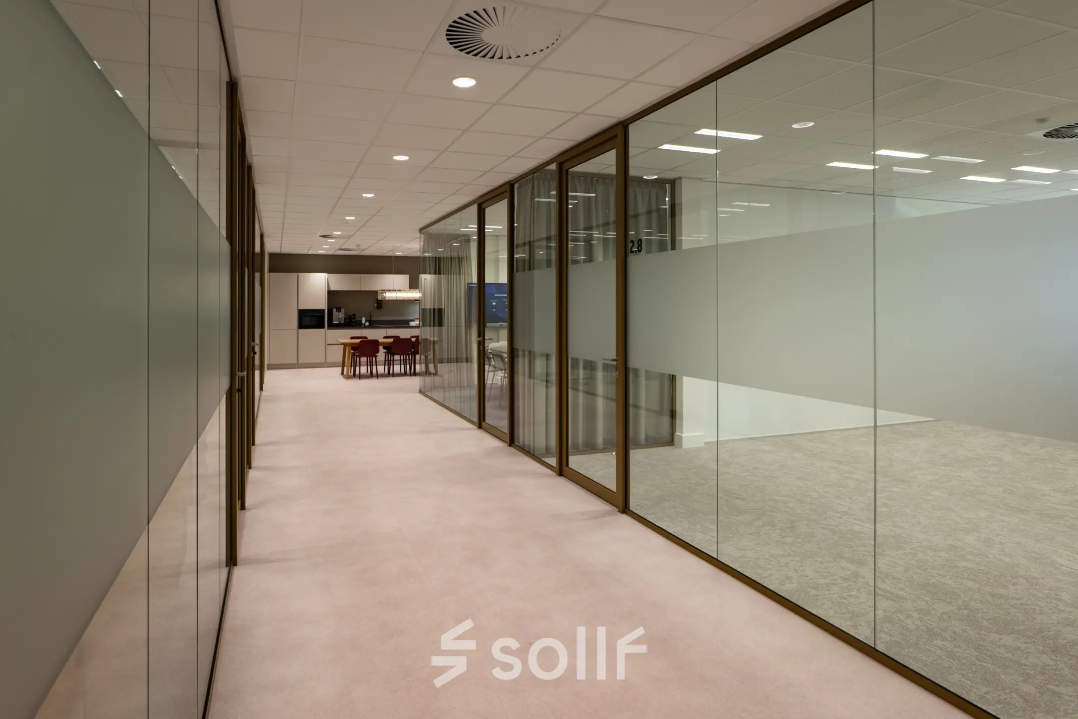 Modern office interior featuring glass walls, leading to a workspace area at Kuipersdijk 2-4, Enschede. Ideal for office space rental.