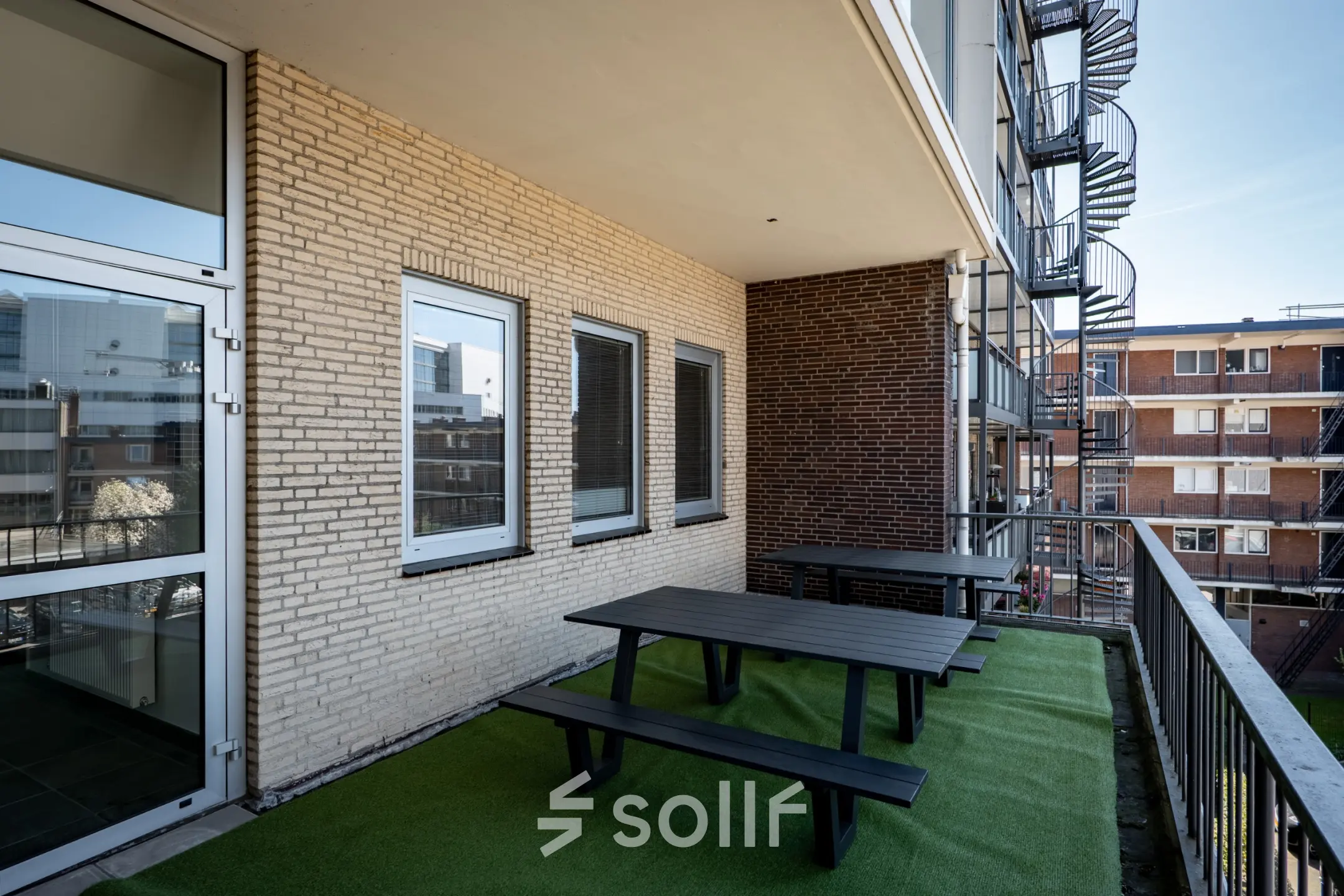 Outdoor office space at Kuipersdijk 2-4, Enschede, featuring a balcony with picnic tables, ideal for informal meetings or breaks. Perfect addition for those seeking office space rental in Enschede.