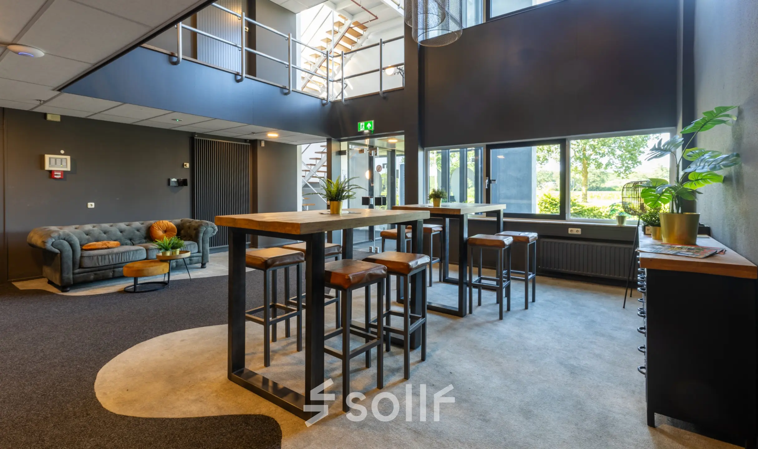 Bright, stylish office lounge at Marssteden 20, Enschede, ideal for office space rental with high ceilings and modern furnishings.