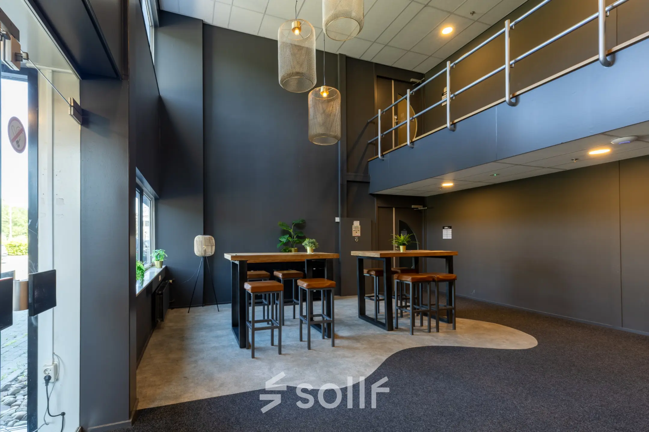 Modern office space with high ceilings and stylish lighting at Marssteden 20, Enschede, available for rent. Features tall tables and stools creating a functional open-floor layout.