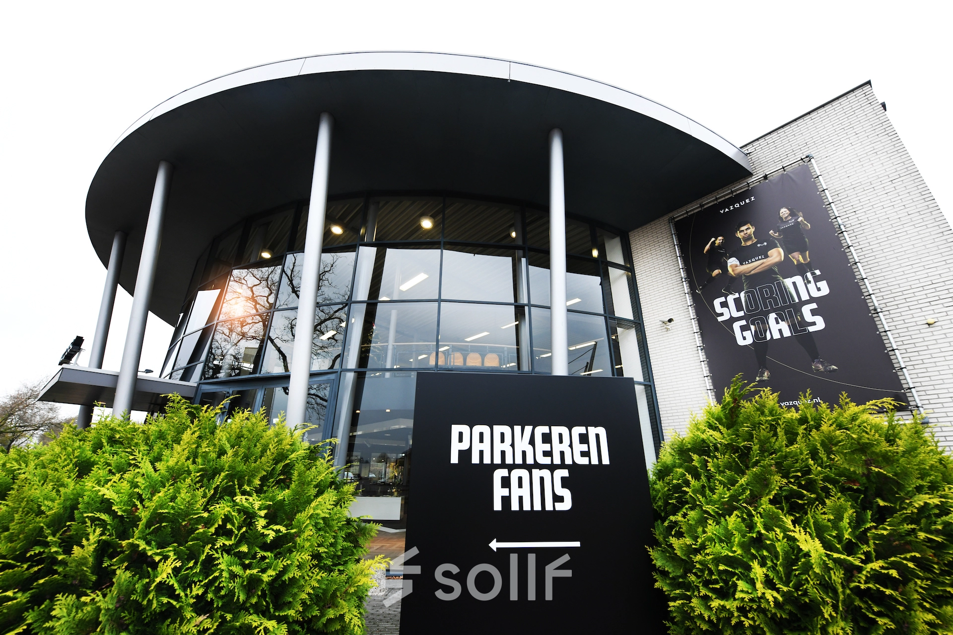 Exterior view of the office space available for rent at Parkweg 102, Enschede, with sleek glass windows and greenery.