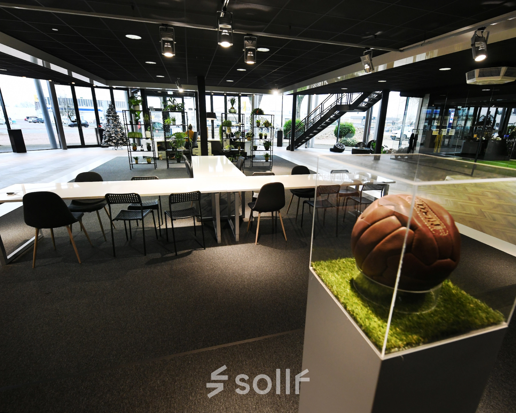 Spacious and modern office to rent at Parkweg 102, Enschede, featuring ample seating and unique decorative elements like a vintage football display.