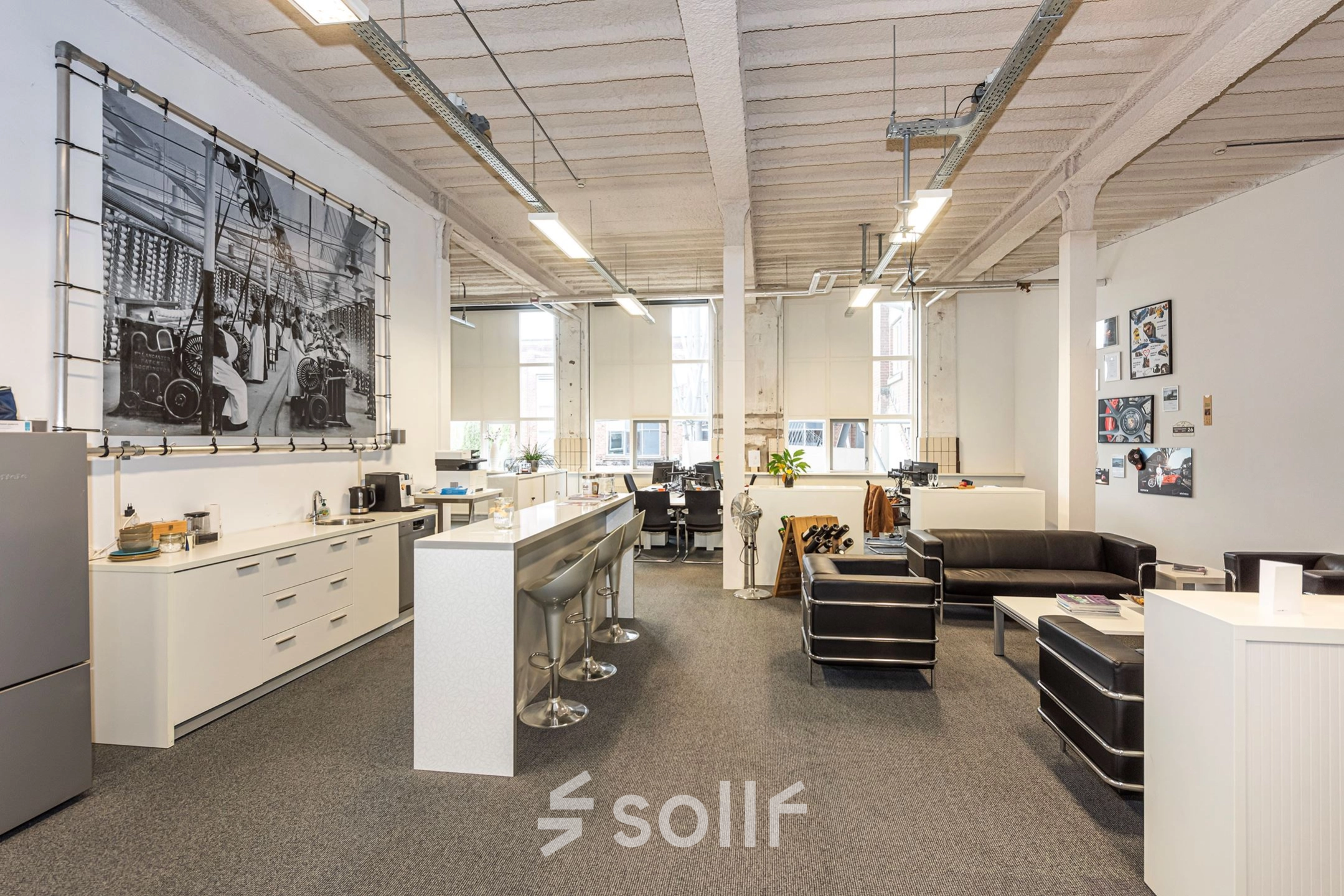 Modern office space in Enschede featuring comfortable seating, high ceilings, and natural light. Ideal for businesses seeking office space rental with stylish furnishings.