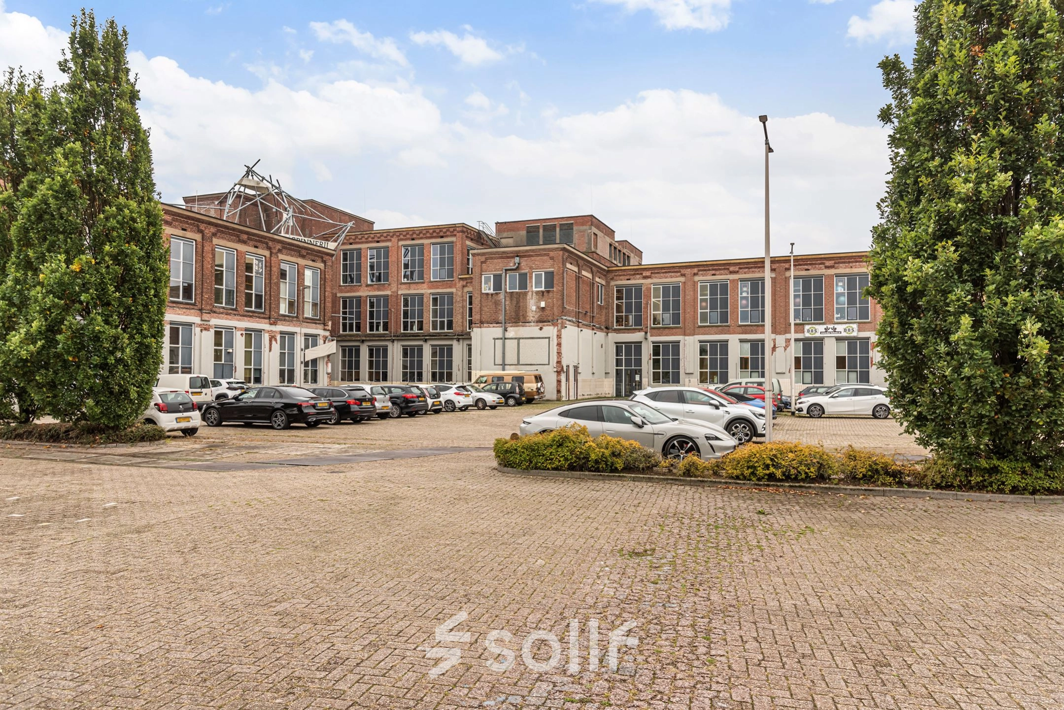 Exterior view of the office building located at Rigtersbleek-Zandvoort 10, Enschede, showcasing available office space rental with ample parking.