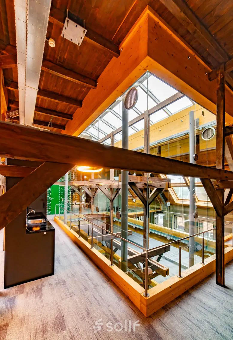Spacious office with exposed wooden beams and a view of the open floorplan at Prins Hendrikkade 3 in Franeker, ideal for office space rental.