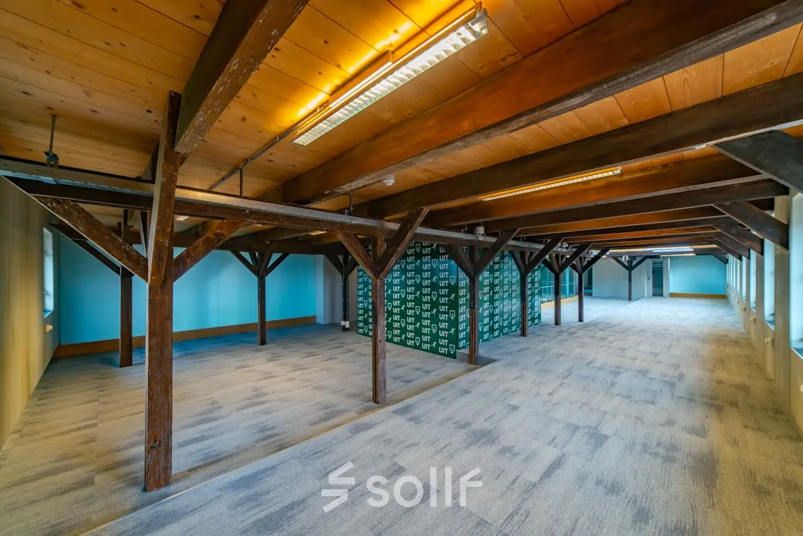 Spacious office to rent at Prins Hendrikkade 3, Franeker featuring an open floor plan with exposed beams and new carpeting, perfect for flexible office space rental opportunities.