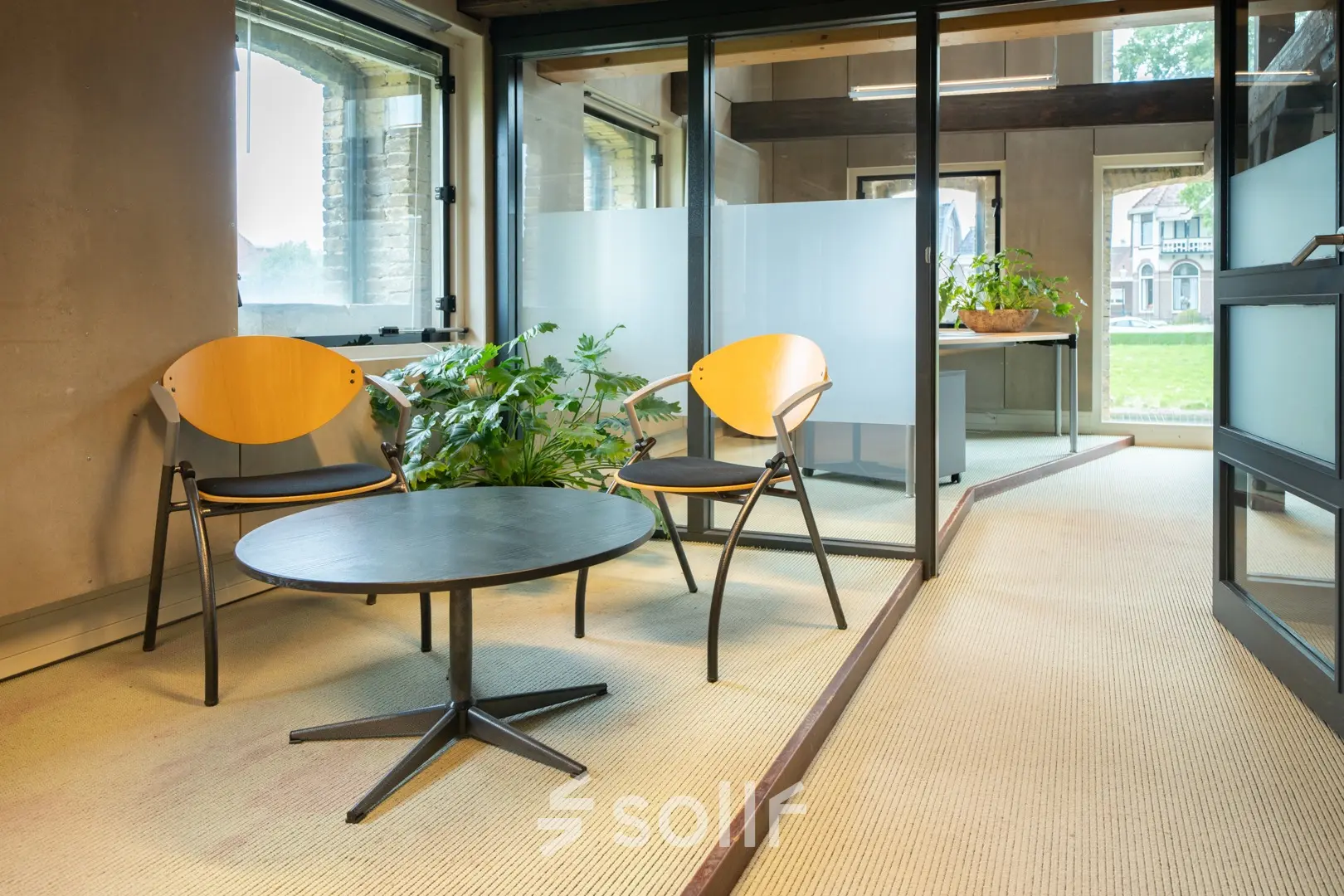 Cozy office space with seating area and greenery at Prins Hendrikkade 3, perfect for rent office space opportunities.