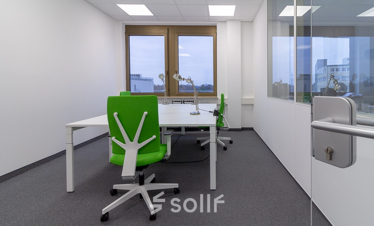 Modern office space rental in Frankfurt West with large windows, stylish green chairs, and desks for collaborative work.