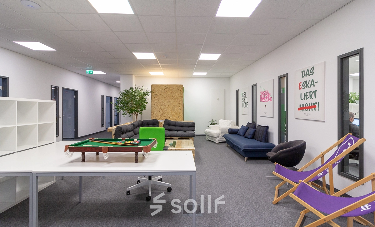 Bright workspace with couches, a table, a pool table, and wall art in Frankfurt West, ideal for office space rental.