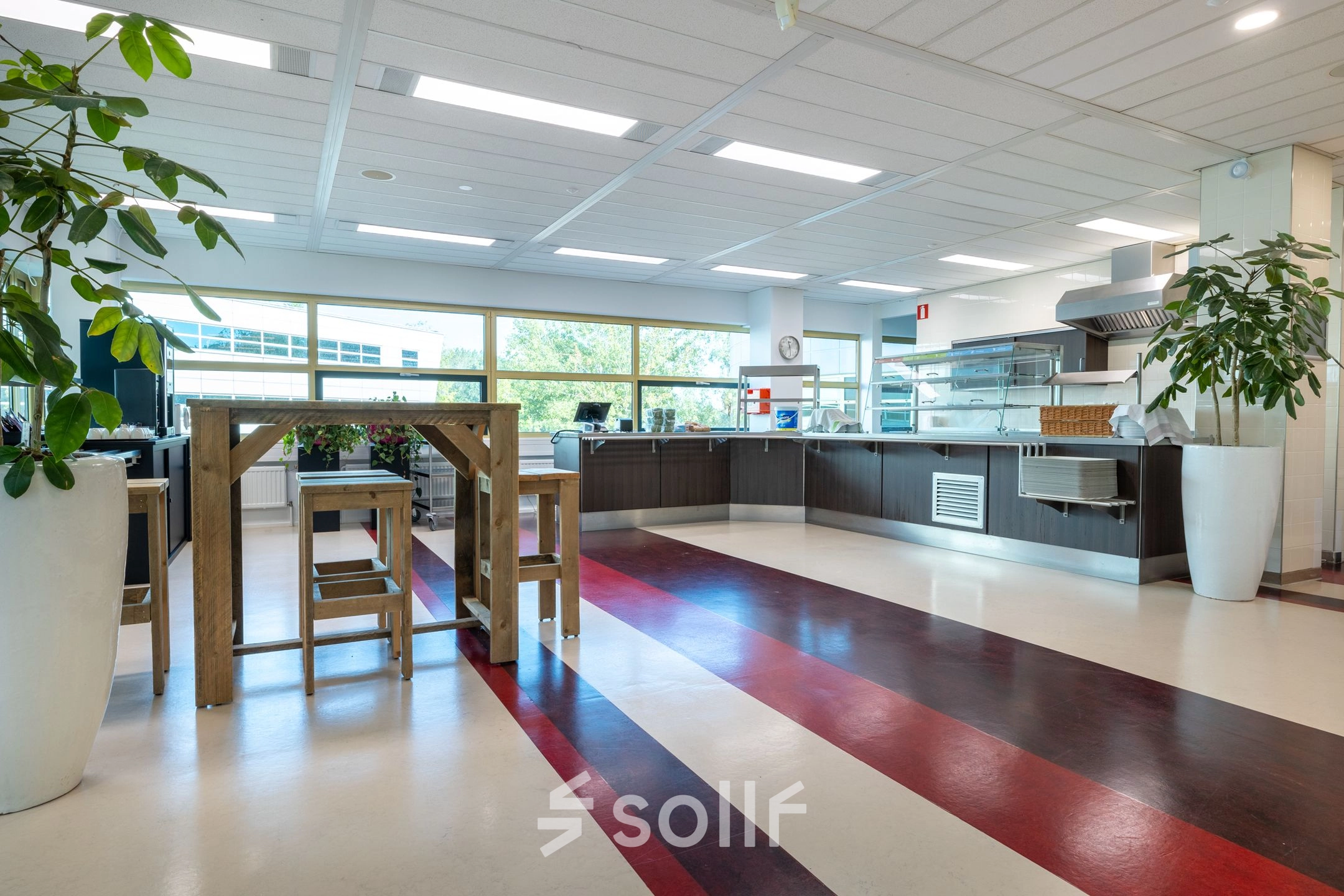 Spacious office pantry with wooden tables, chairs, and large windows at Groningenweg 8 8, Gouda, ideal for office space rental.