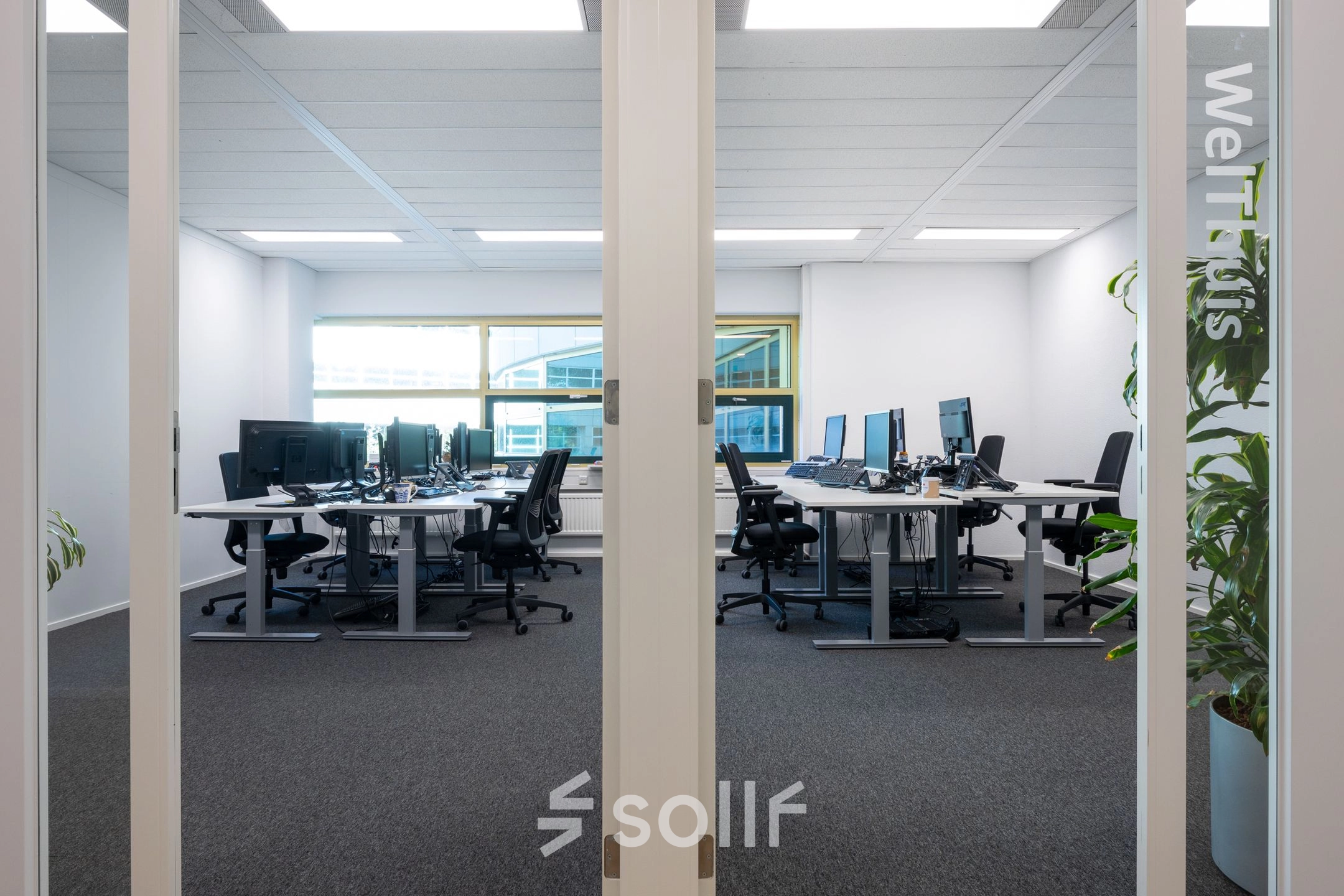 Spacious office at Groningenweg 8 8, Gouda, with modern workstations set up for rent. Large windows and ergonomic chairs create a welcoming environment for office space rental.