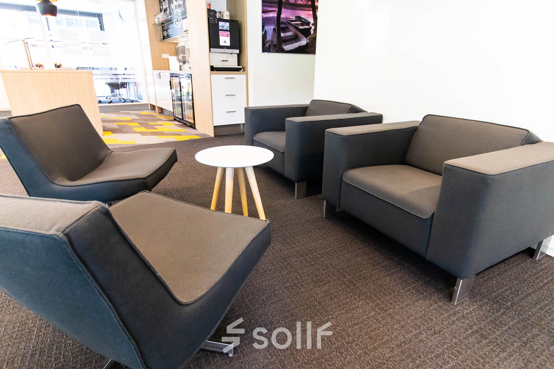 Modern office space to rent at Kampenringweg 45, Gouda, featuring comfortable seating and vibrant carpet design.