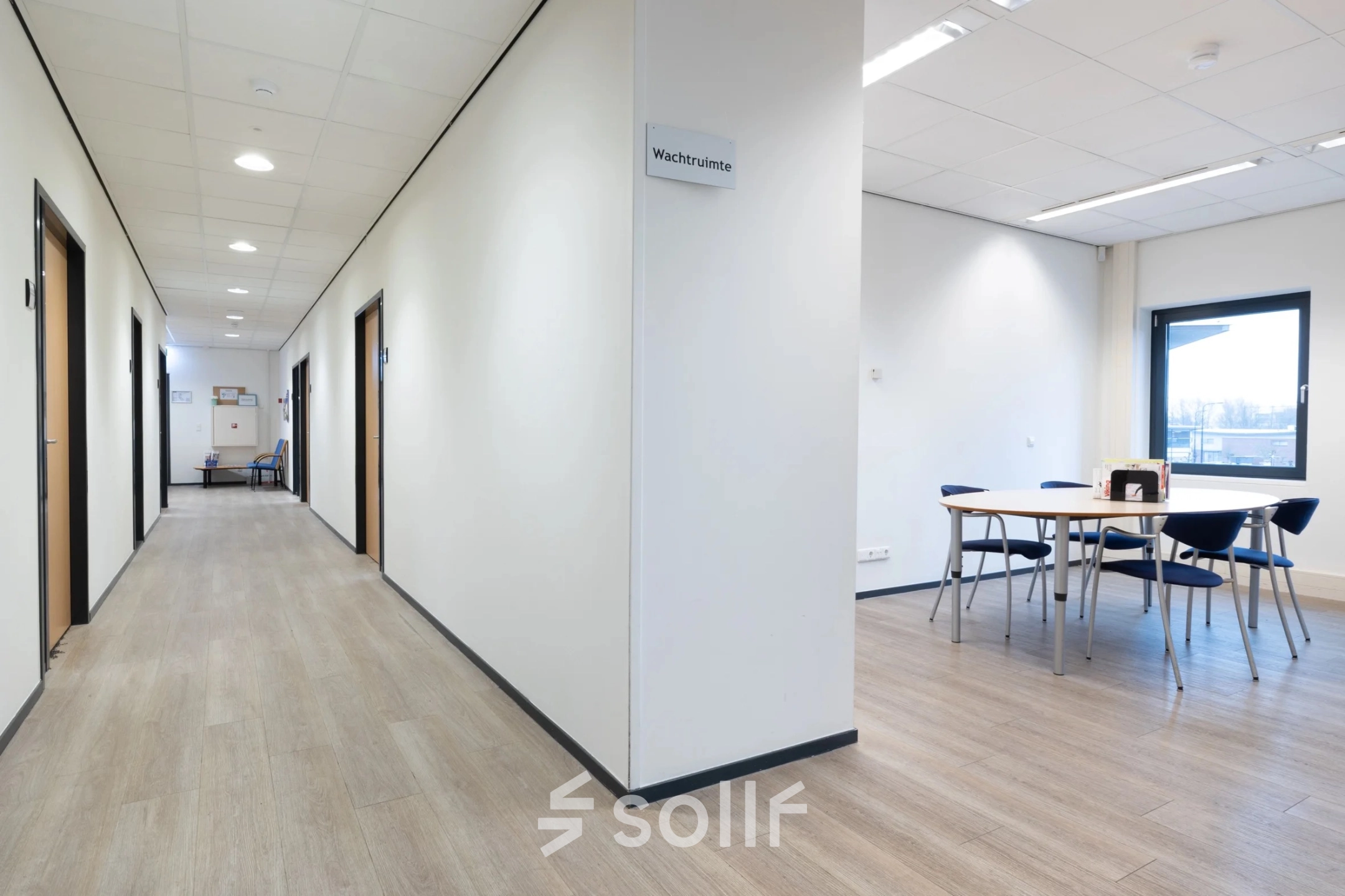 Interior office space at Zuidelijk Halfrond 1, Gouda featuring a hallway and a small furnished meeting area, ideal for office space rental.