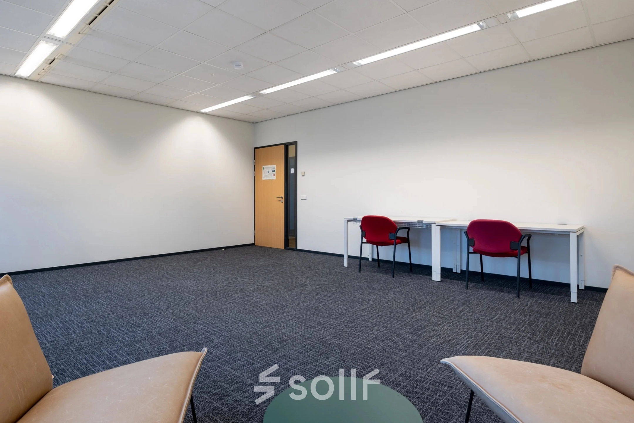 Spacious office for rent at Zuidelijk Halfrond 1, Gouda, featuring a minimalist design with carpeting, two desks, and chairs for a comfortable work setting.