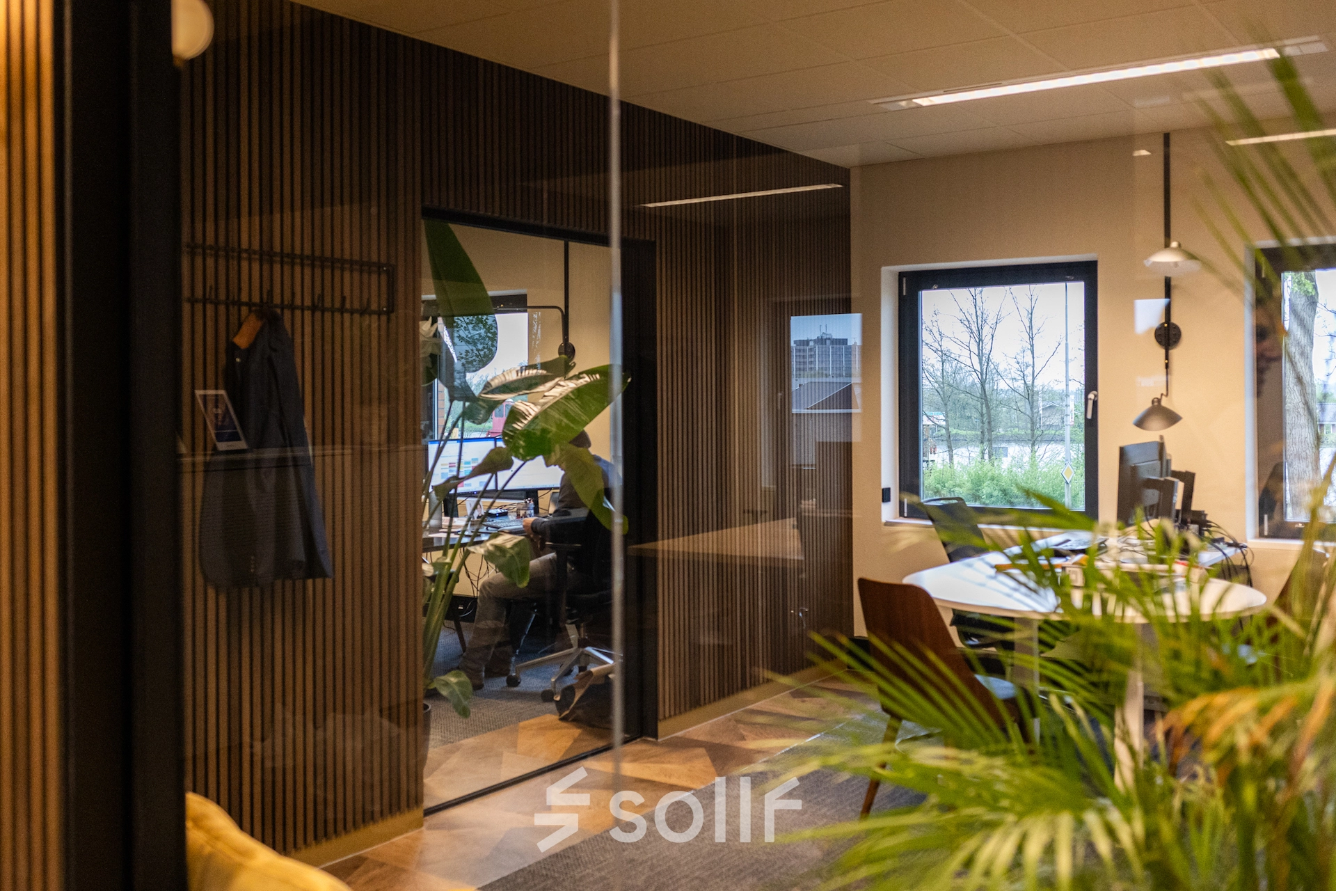 Modern office space available for rent at Zuidelijk Halfrond 1, Gouda, featuring natural light, plants, and sleek furnishings.