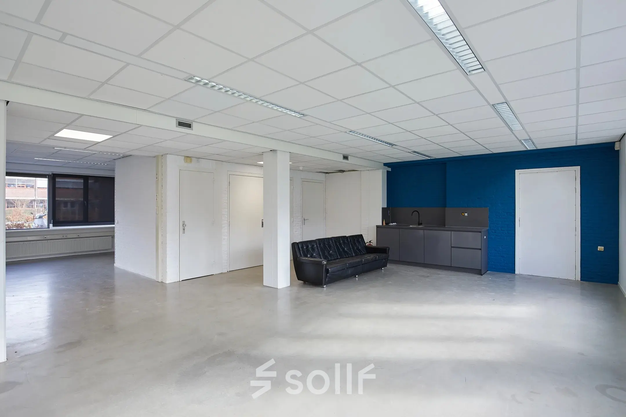 Spacious and bright office space at Schweitzerlaan 12, Groningen, available for rent. The office features a sleek kitchenette and ample natural light, ideal for efficient workspace rental.