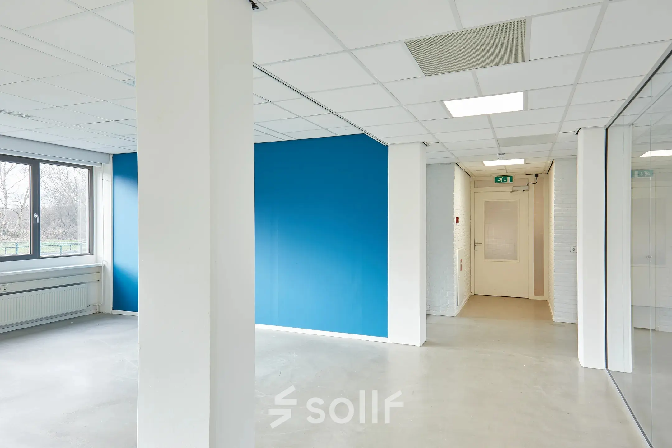 Interior of an unfurnished office space with blue accent wall at Schweitzerlaan 12, Groningen, available for office space rental.