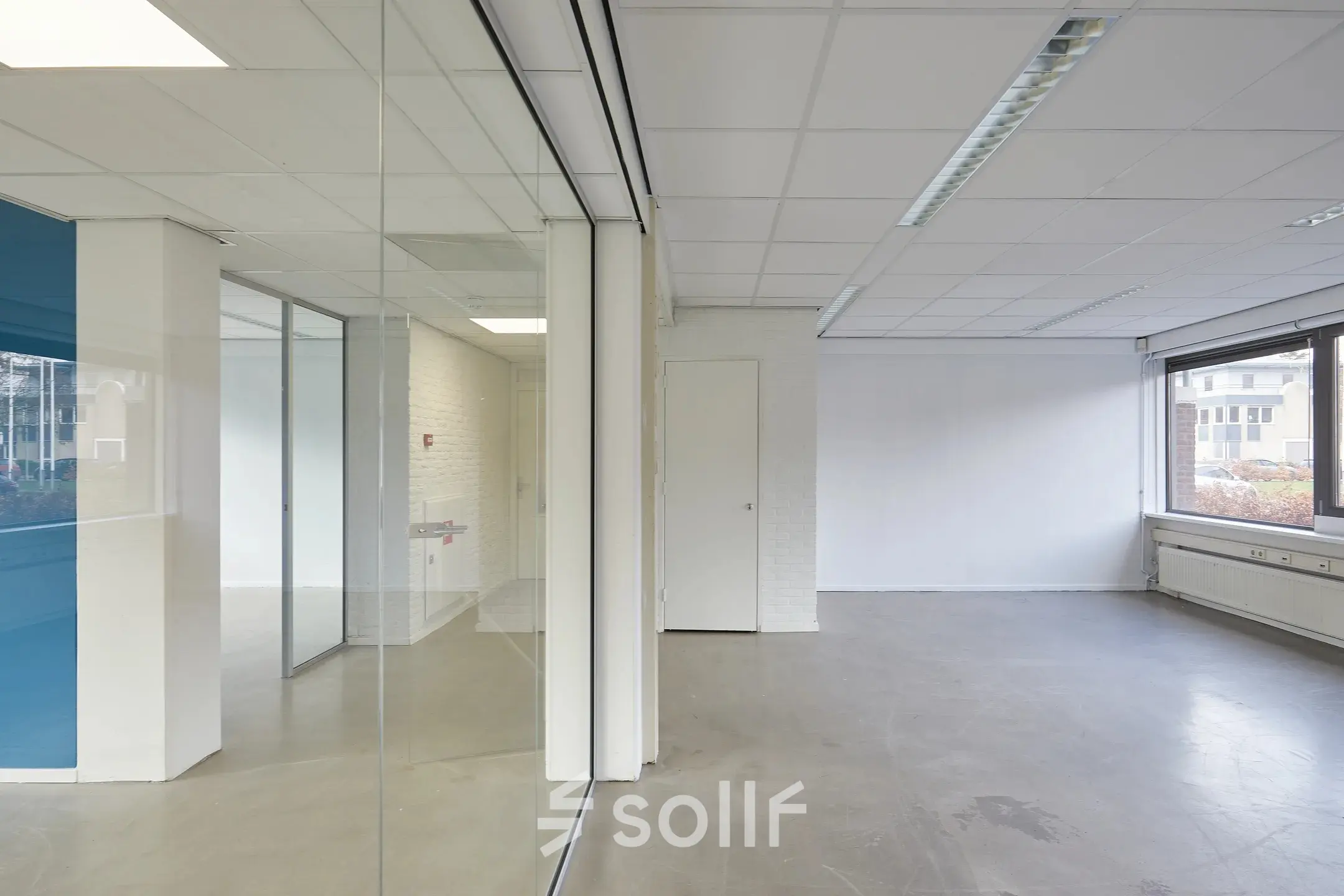 Bright, unfurnished office space available for rent at Schweitzerlaan 12, Groningen with large windows and glass partitions.