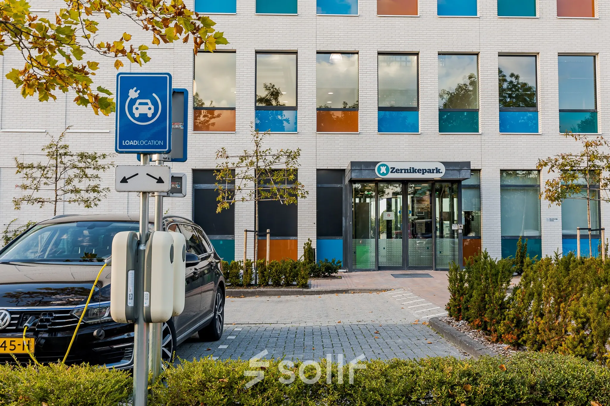 Exterior view of office building at Zernikepark 12 in Groningen, showing parking and entrance for office space rental.