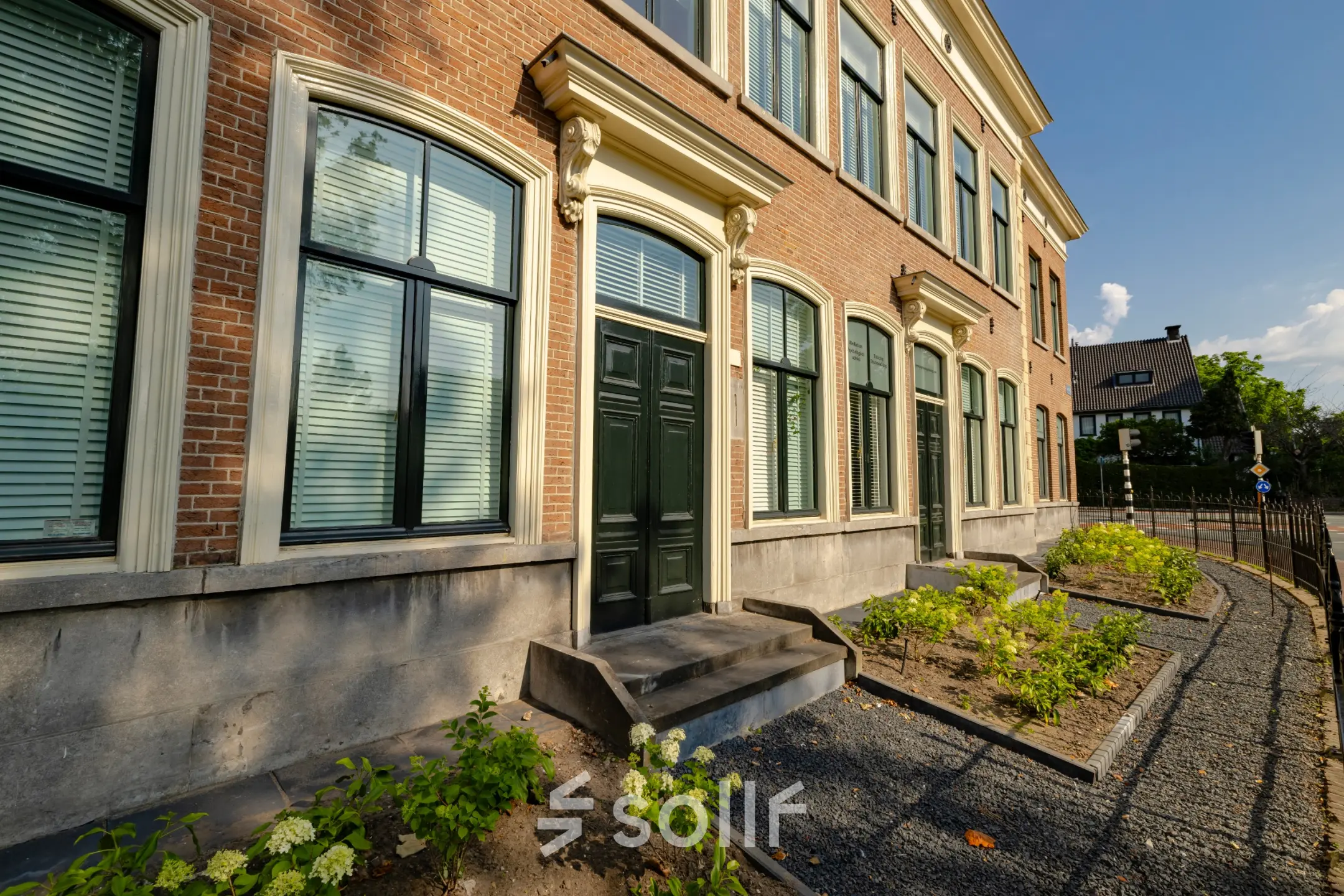 Exterior view of office space available for rent at Kennemerplein 20 in Haarlem Centraal Station, showcasing a historic brick facade and large windows.