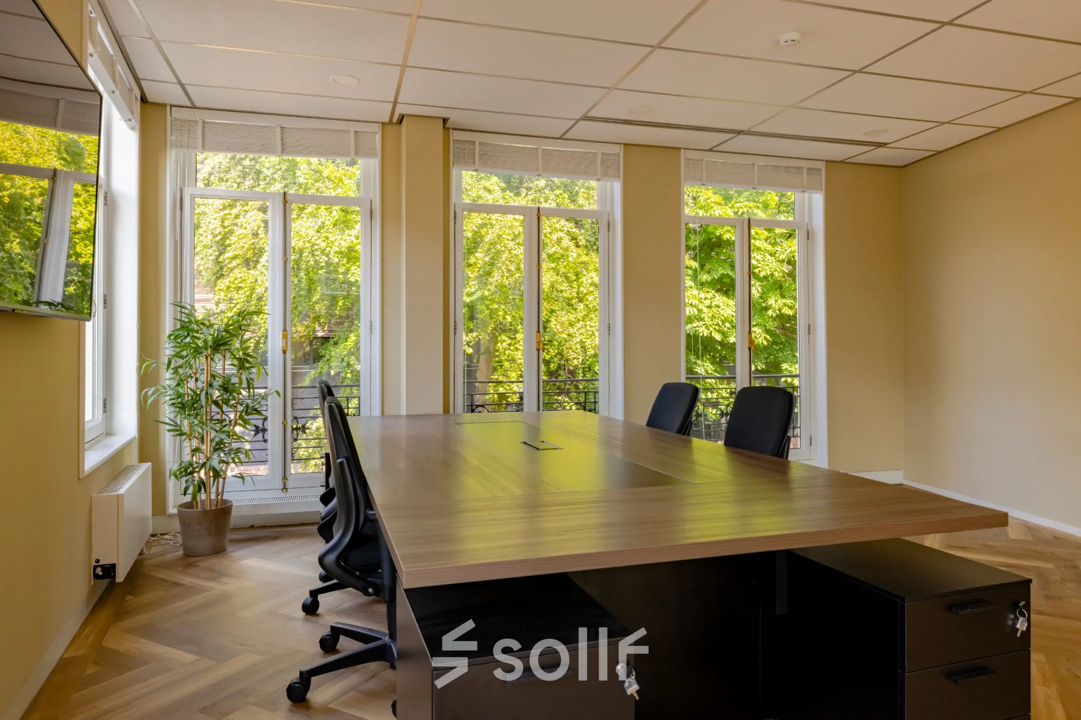 Bright office space to rent at Kennemerplein 20, featuring large windows, modern furnishings, and a spacious work area.
