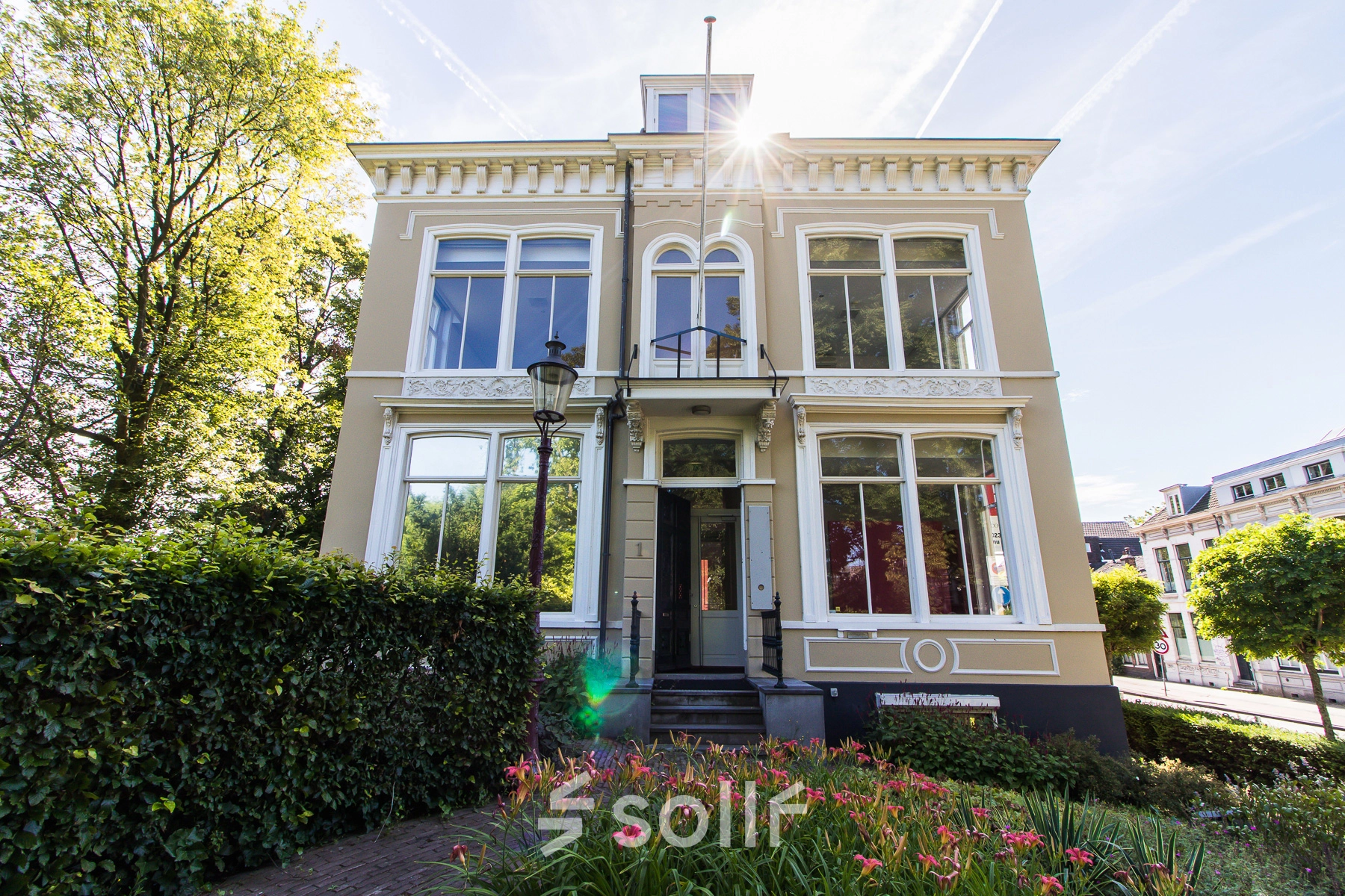 Exterior view of the office to rent at Prinsen Bolwerk 1, Haarlem Centraal Station, featuring a classic facade surrounded by greenery.