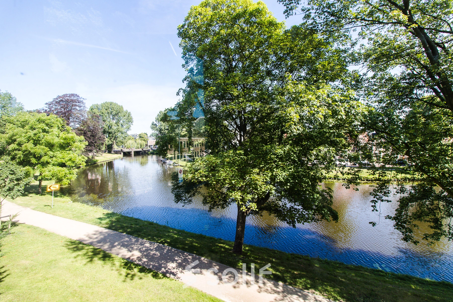 View of serene park with water feature near Prinsen Bolwerk 1, Haarlem Centraal Station, ideal for those seeking office space rental amidst nature.