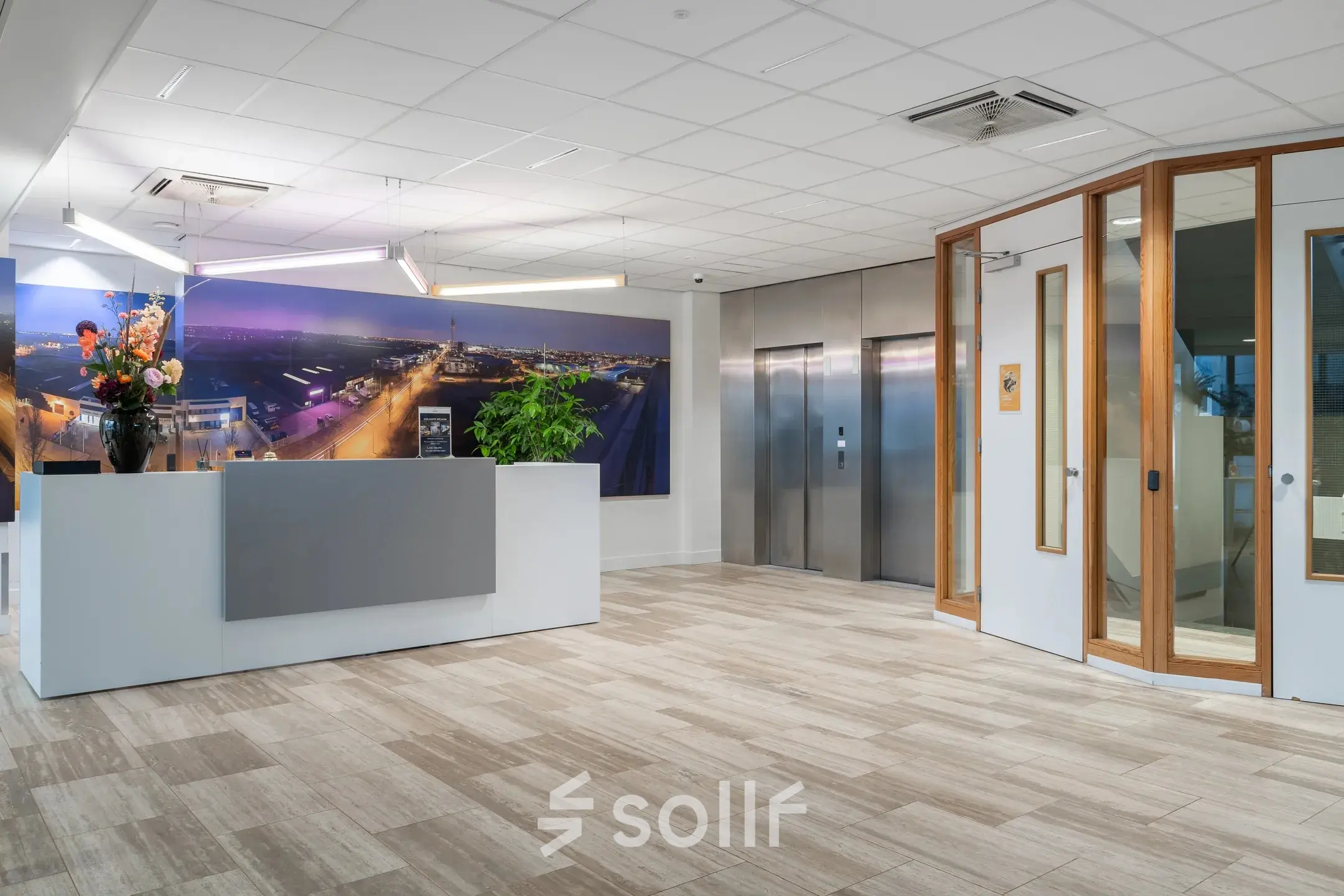 Modern office entrance with a reception desk and elevators at A. Hofmanweg 5A, Haarlem Waarderpolder. Ideal office space rental for businesses.