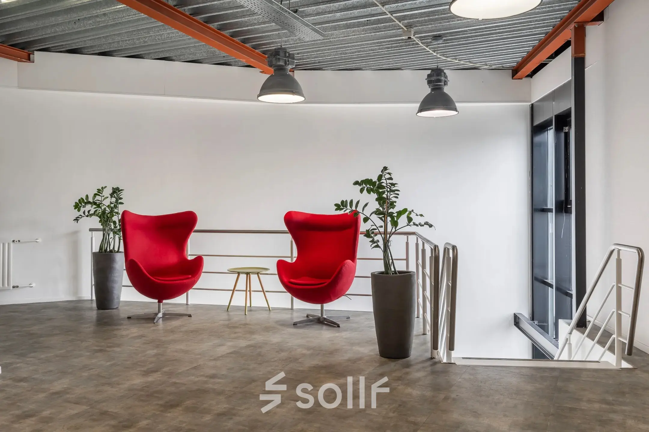Stylish office space at Haarlem Waarderpolder with vibrant red chairs and plants offering a modern workspace environment suitable for office space rental.