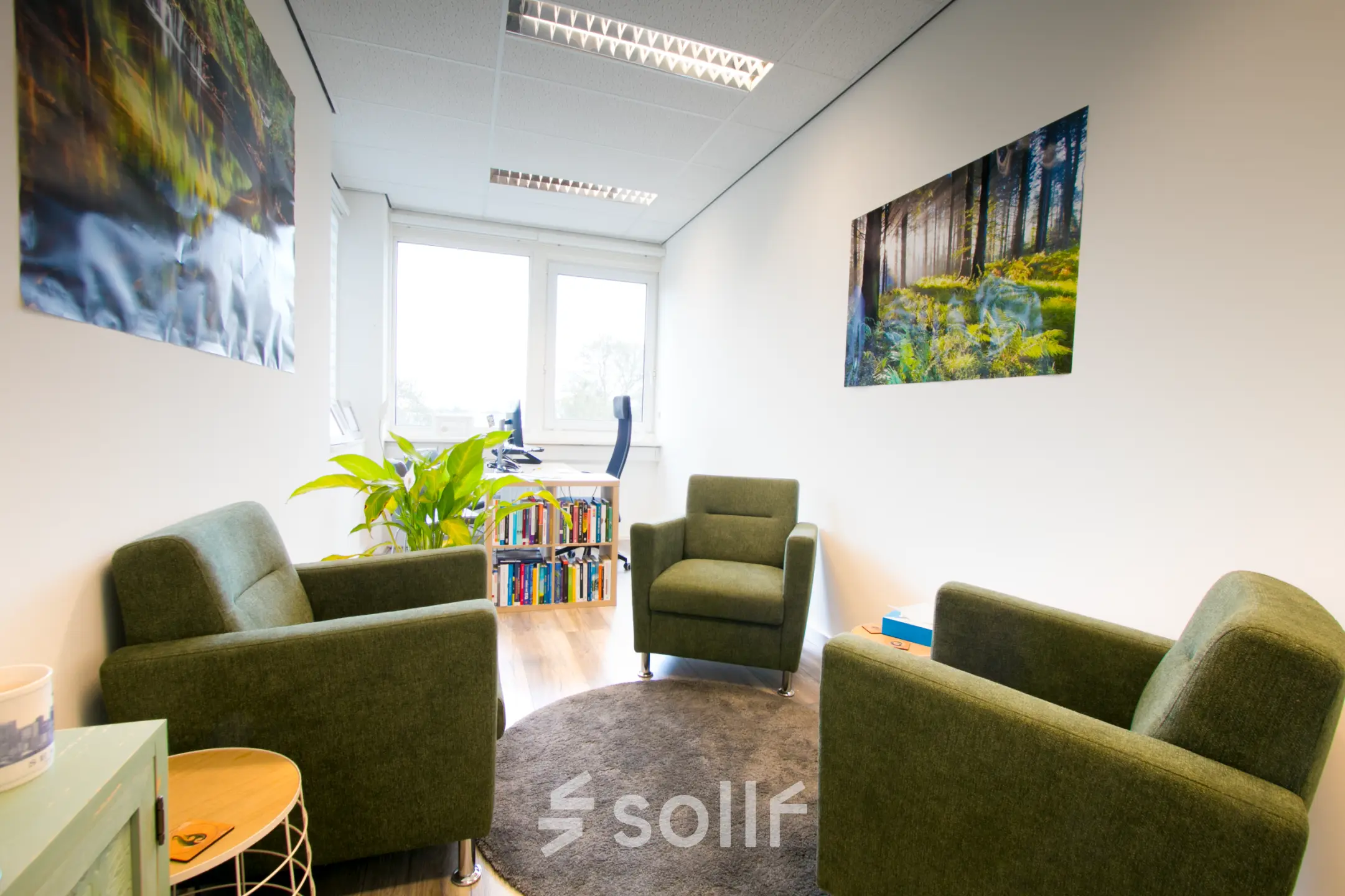 Cozy office space at Waarderweg 19, Haarlem Waarderpolder, featuring green armchairs, nature-themed artwork, and a small bookcase. Ideal for rent office space needs.