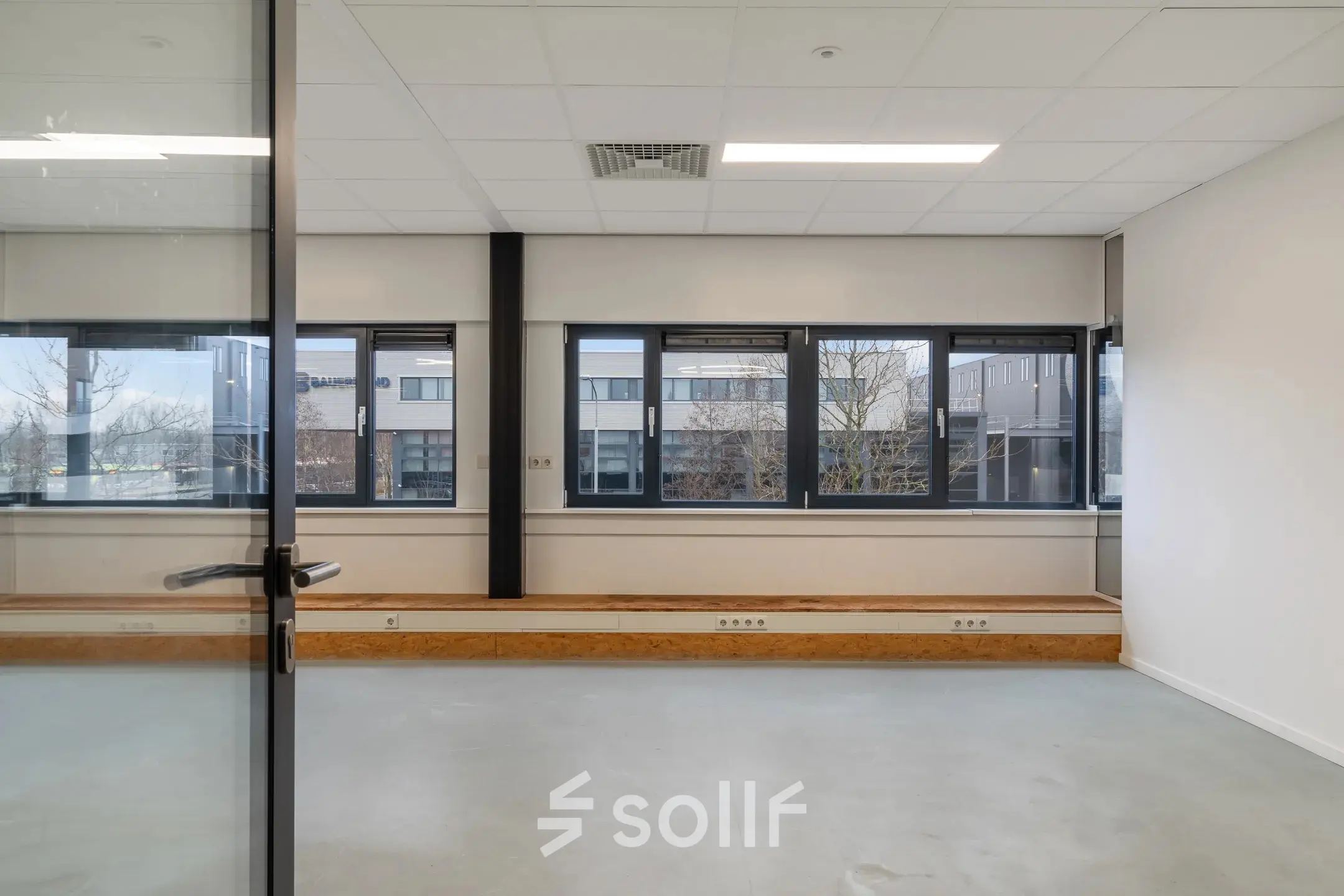 Bright office space with large windows at Waarderweg 52, Haarlem Waarderpolder, available for rent. Simple interior with natural light, perfect for creating a productive environment.
