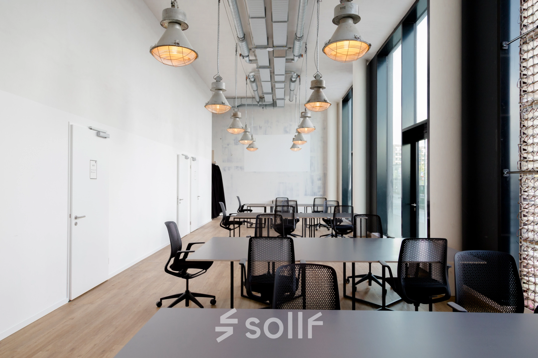 Spacious office space rental at Versmannstraße 4 in Hamburg Hafencity with modern lighting and desks, ideal for collaborative work. Ideal office to rent for dynamic teams.