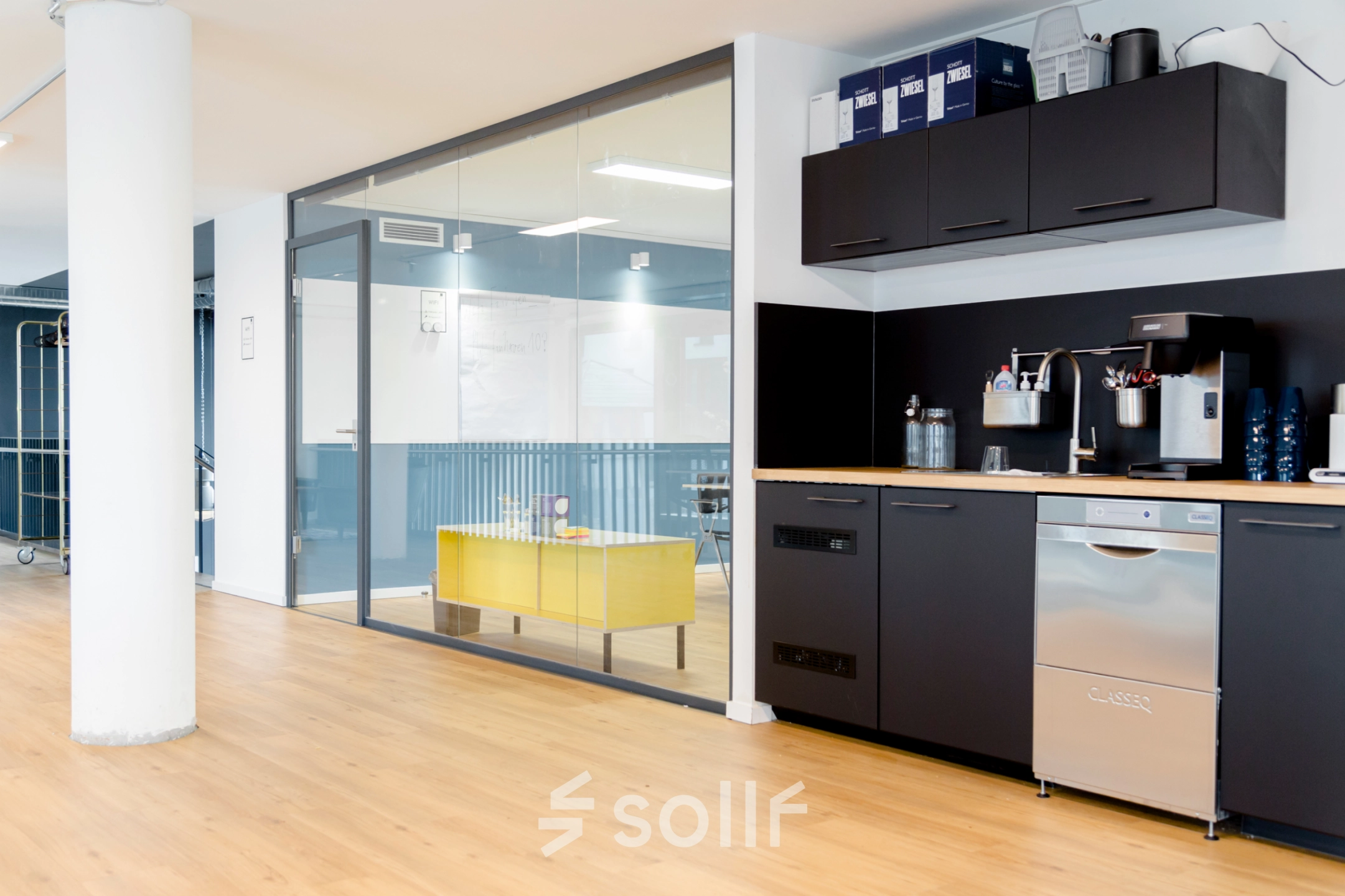 Contemporary furnished interior of an office with a kitchenette and glass-walled workspace at Versmannstraße 4, Hamburg Hafencity available for office space rental.
