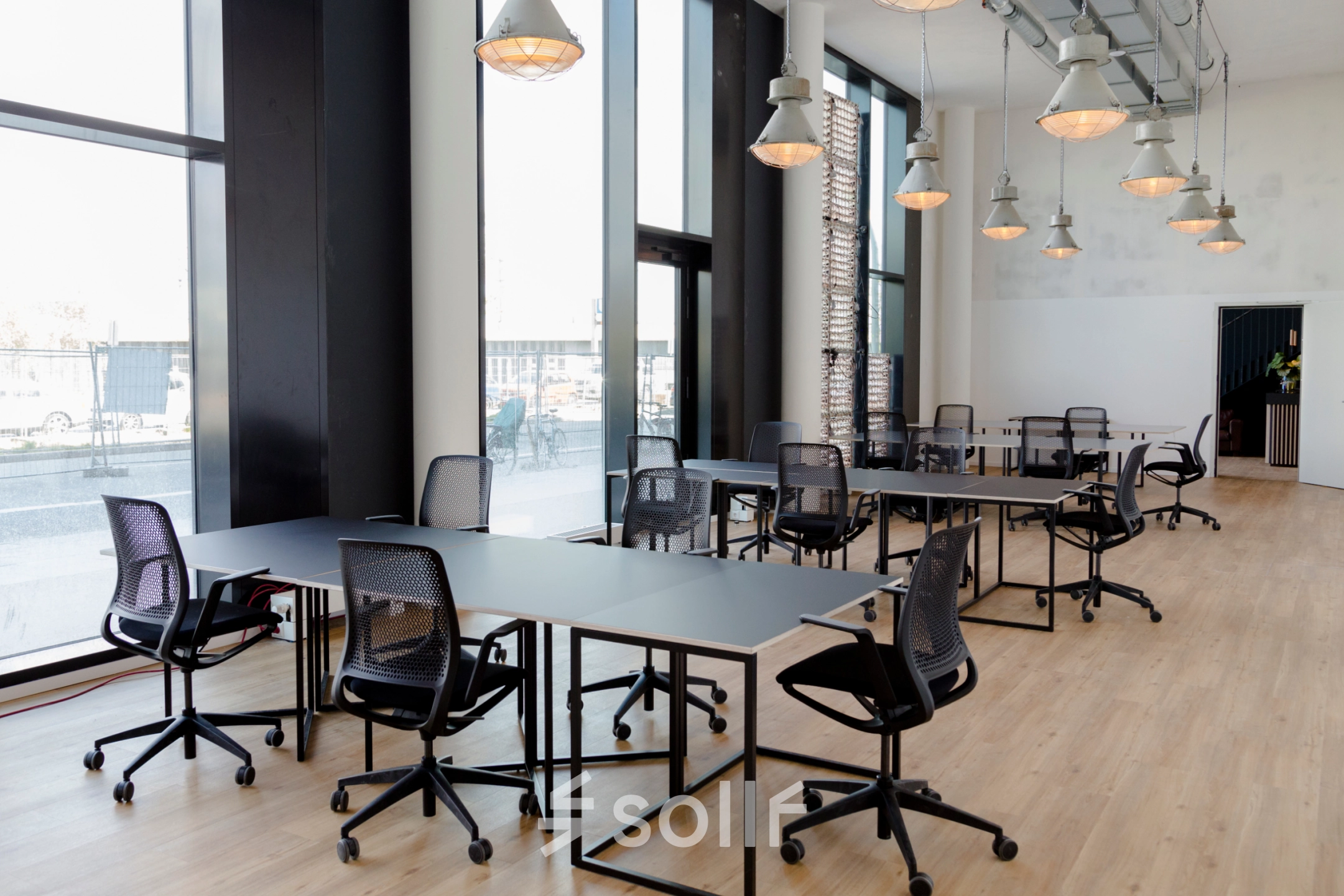 Spacious office to rent at Versmannstraße 4 in Hamburg Hafencity, featuring large windows and modern furniture suitable for collaborative work sessions. Ideal for office space rental.