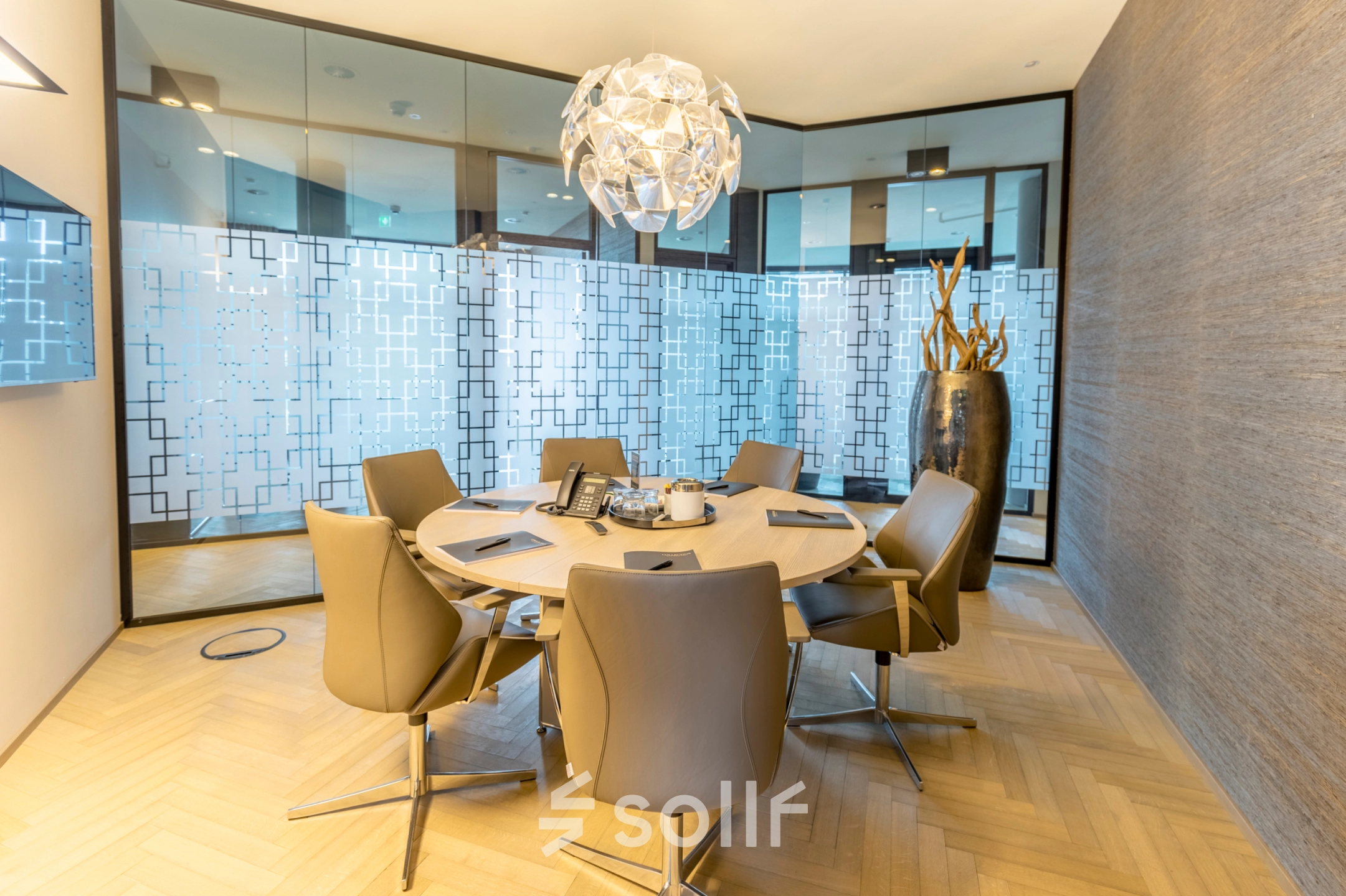 Furnished conference room at Hohe Bleichen 8 in Hamburg Neustadt, ideal for office space rental, featuring a round table, chairs, and a decorative lighting fixture.