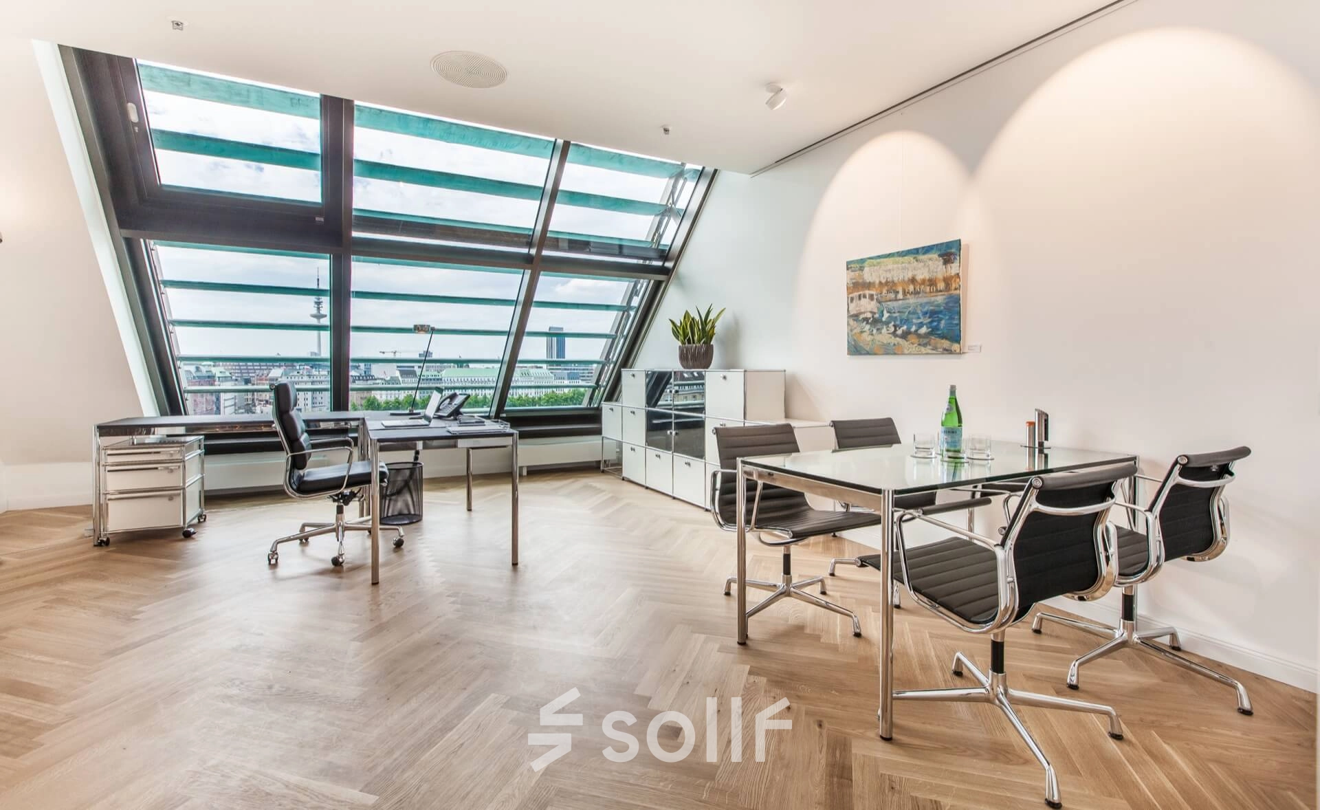 Bright office to rent at Ballindamm 39 with modern furnishings, featuring sleek desks and an impressive view through slanted windows, perfect for office space rental in Hamburg Old Town.