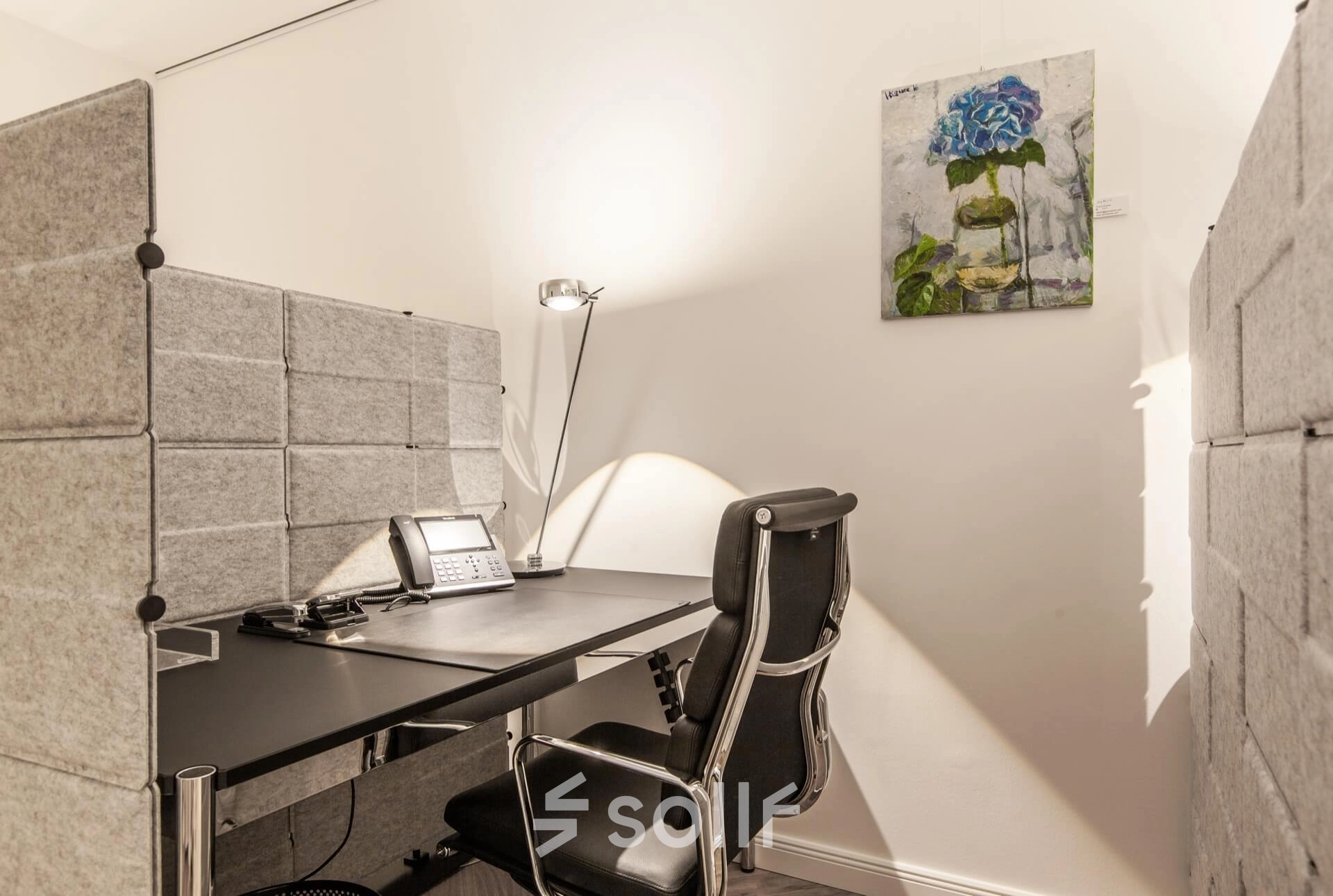 Furnished office space rental at Ballindamm 39, Hamburg Old Town, featuring a sleek desk and chair with modern decor.