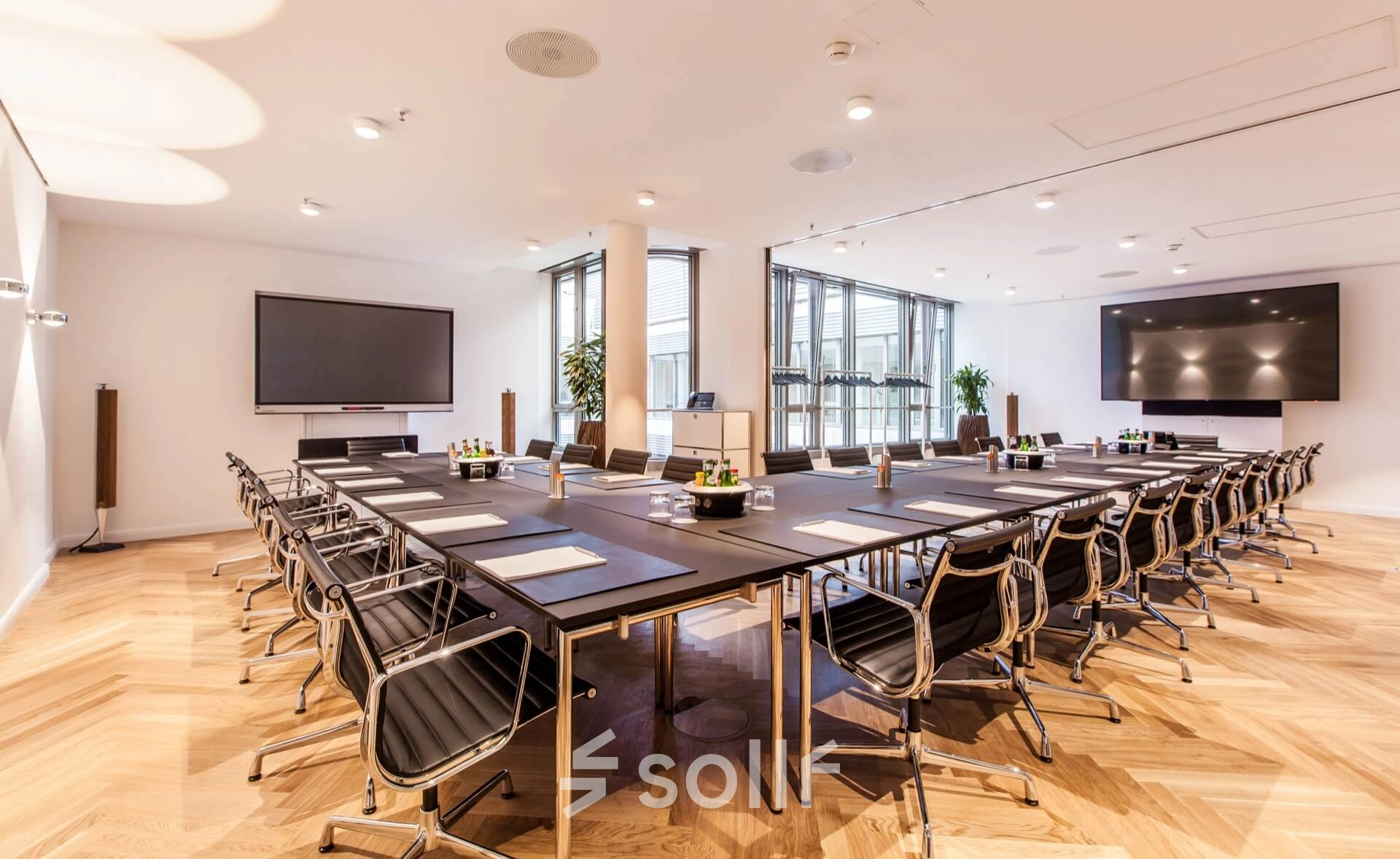 Modern conference room available for office space rental at Ballindamm 39, Hamburg Old Town, featuring sleek furnishings and airy windows.