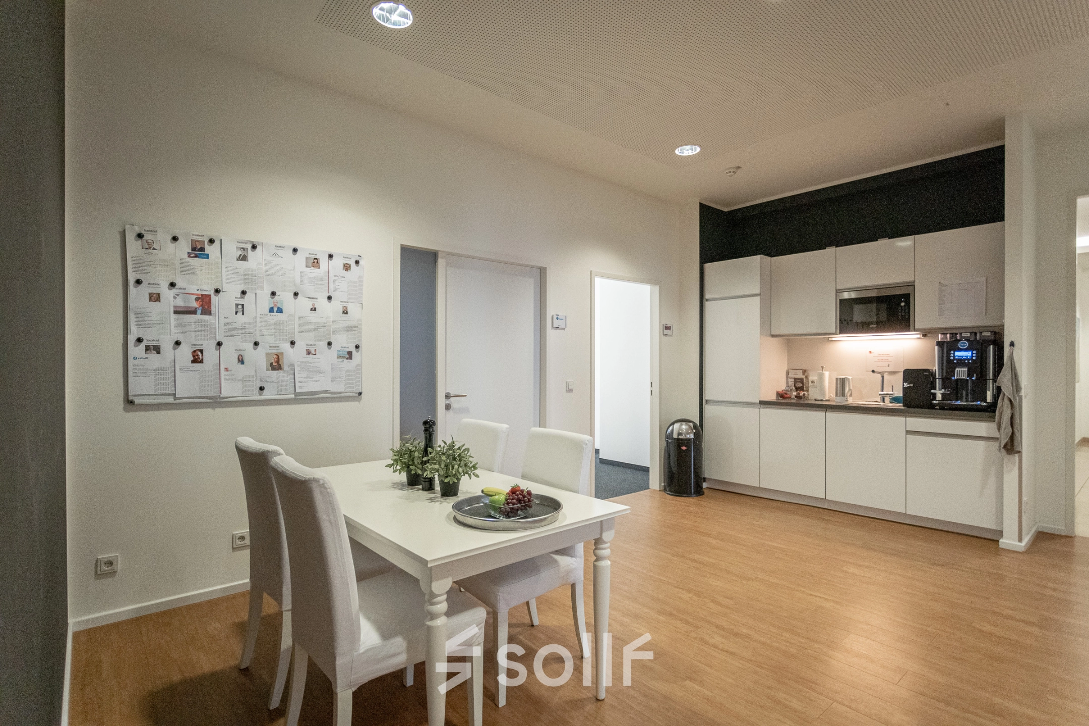 Interior view of a furnished office space at Raboisen 38, Hamburg Old Town, featuring a dining area and kitchenette, available for office space rental.