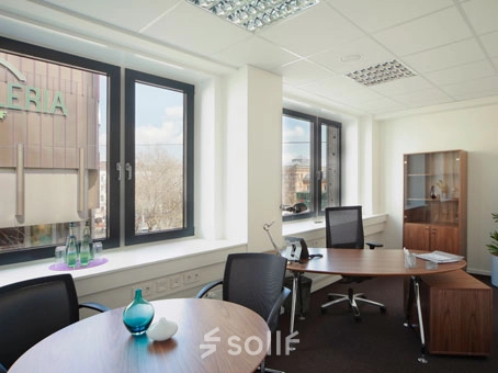 Bright office space rental at Bahnhofstraße 8, Hannover Mitte, featuring modern desks and large windows allowing natural light.