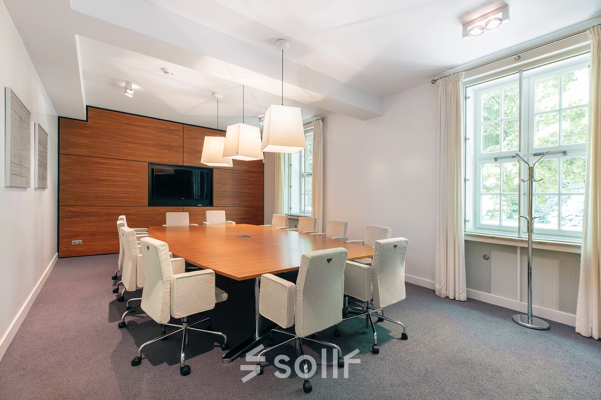 Contemporary conference room at Ceintuurbaan 2, Harderwijk, featuring a sleek wooden table, modern chairs, and a large window allowing natural light. Ideal for office space rental.