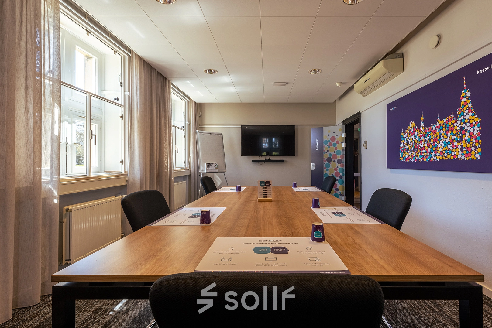 Bright conference room at Ceintuurbaan 2, Harderwijk, featuring a large wooden table, chairs, and wall-mounted screen, perfect for office space rental.