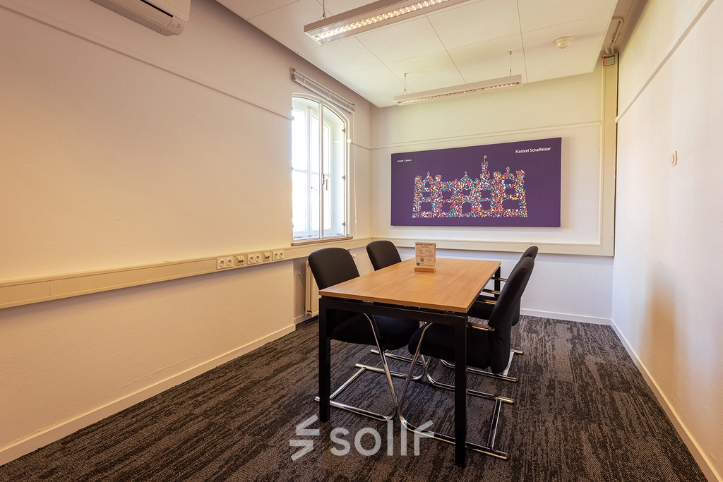 A modest, well-lit conference room in Harderwijk at Ceintuurbaan 2 featuring a table and chairs, suitable for small meetings. Ideal for those seeking office space rental.