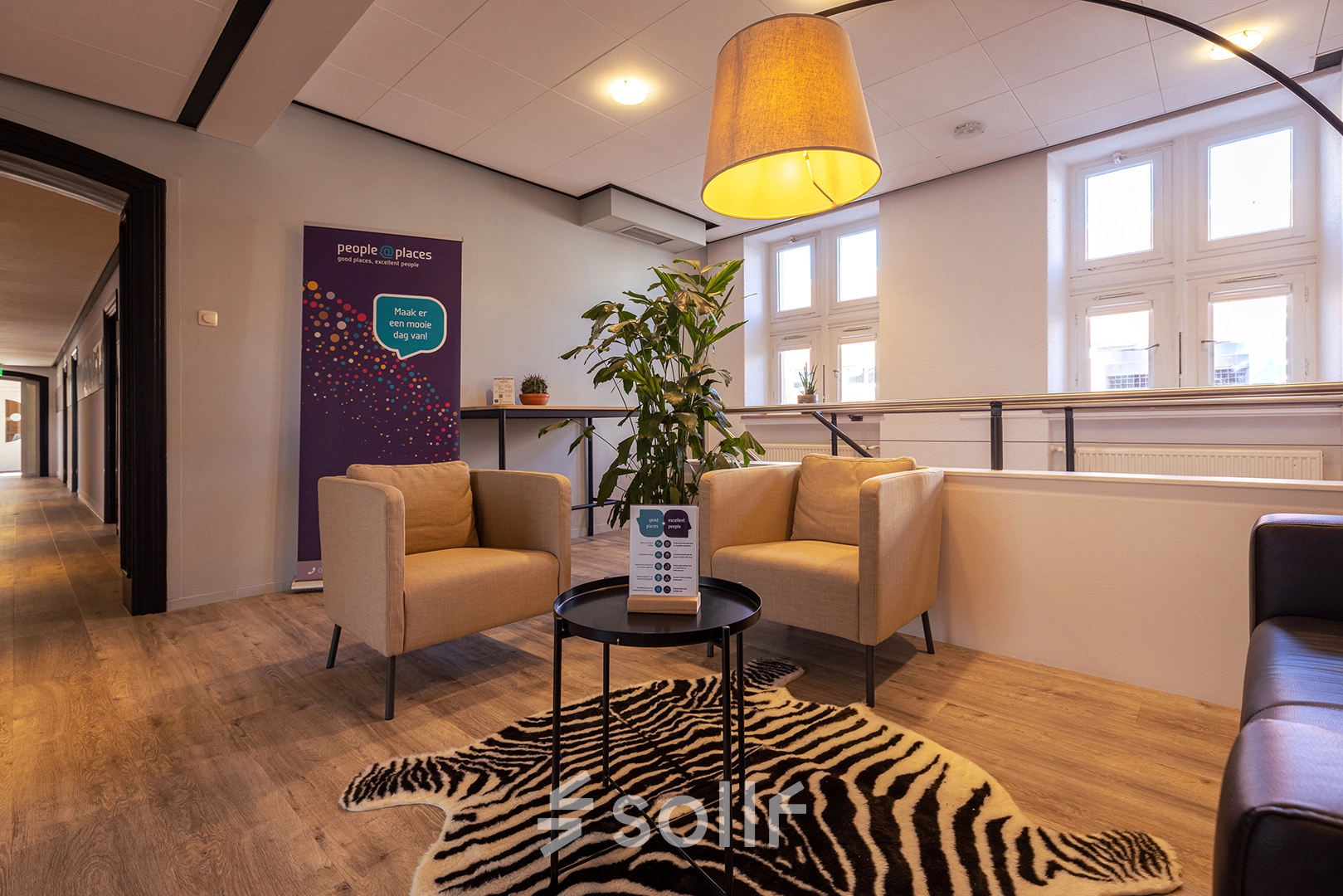 Cozy seating area with armchairs and a table on a zebra rug in an office located in Harderwijk, offering a welcoming space for office space rental.