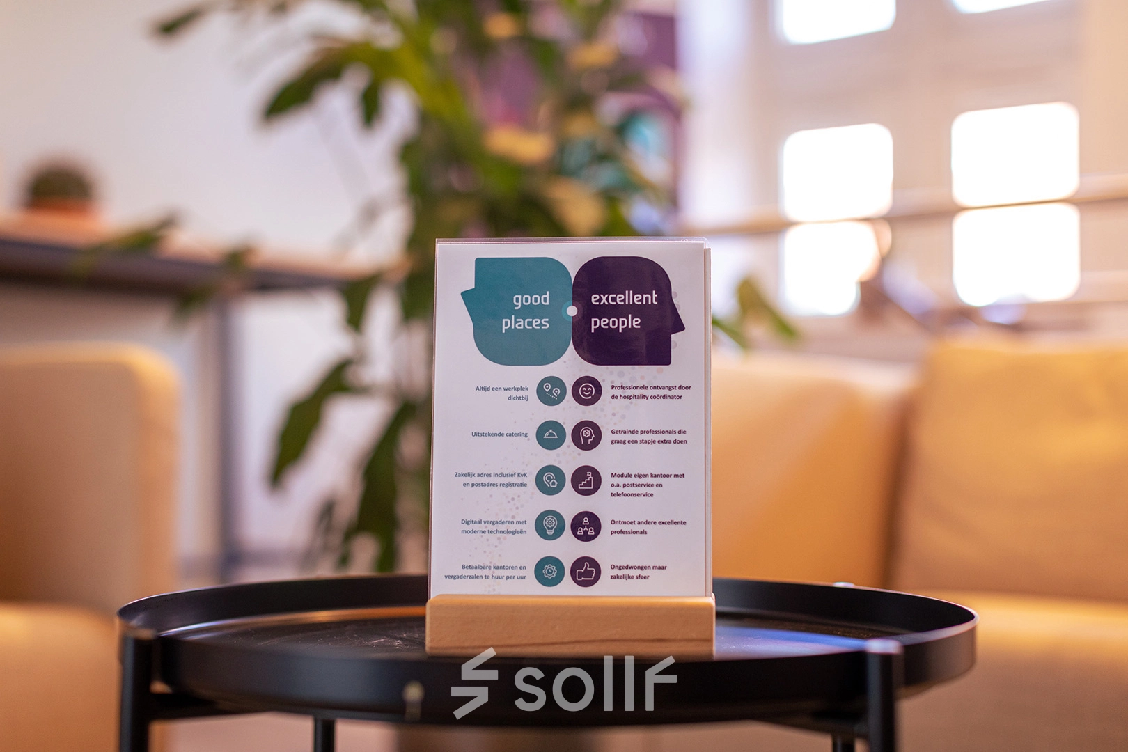 Bright office interior at Ceintuurbaan 2, Harderwijk, showcasing cozy lounge area, ideal for rent office space. Features a stylish table with informational brochure, set against a backdrop of soft lighting and greenery.