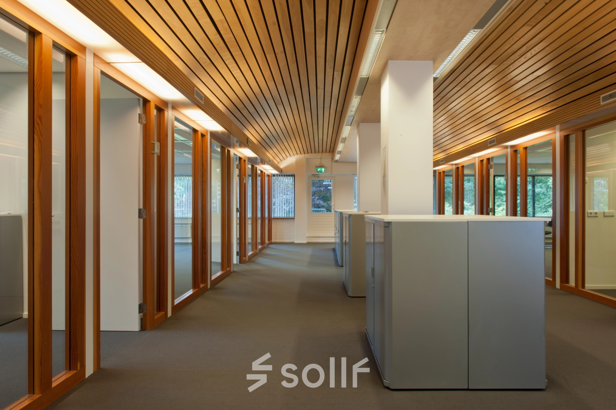 Office space for rent at Herenweg 115 in Heemstede featuring a corridor with wooden accents, glass doors, and ample natural light.
