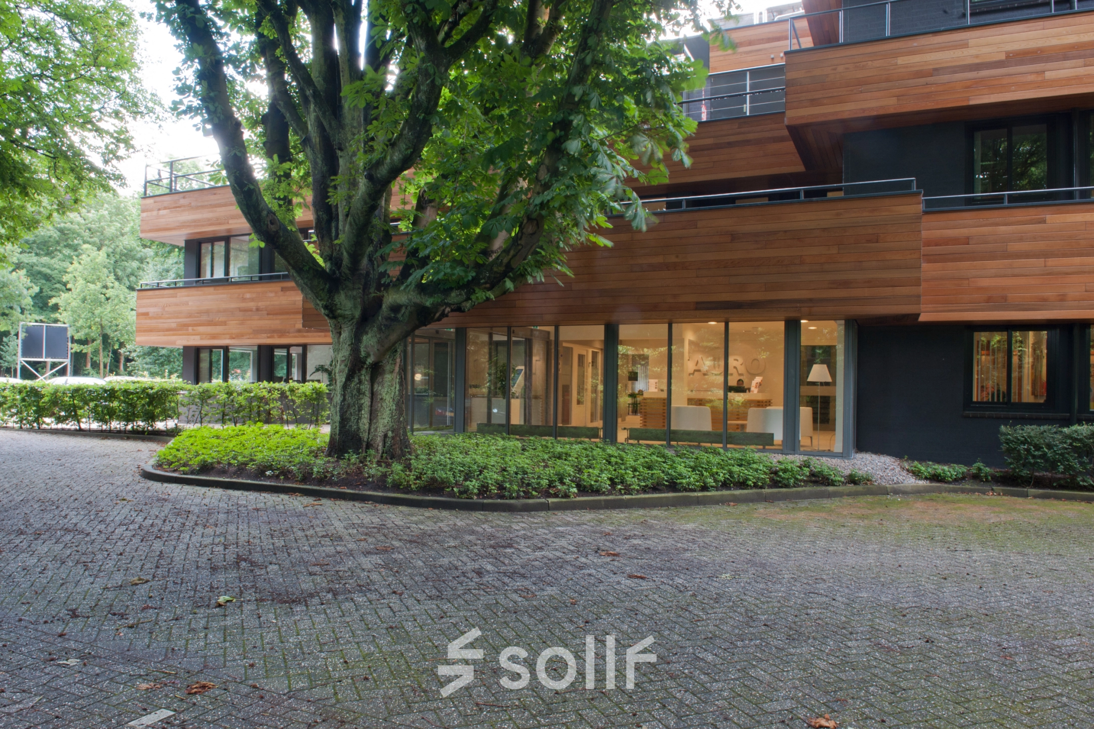 Exterior view of office to rent at Herenweg 115, Heemstede with modern architecture and surrounded by lush greenery.